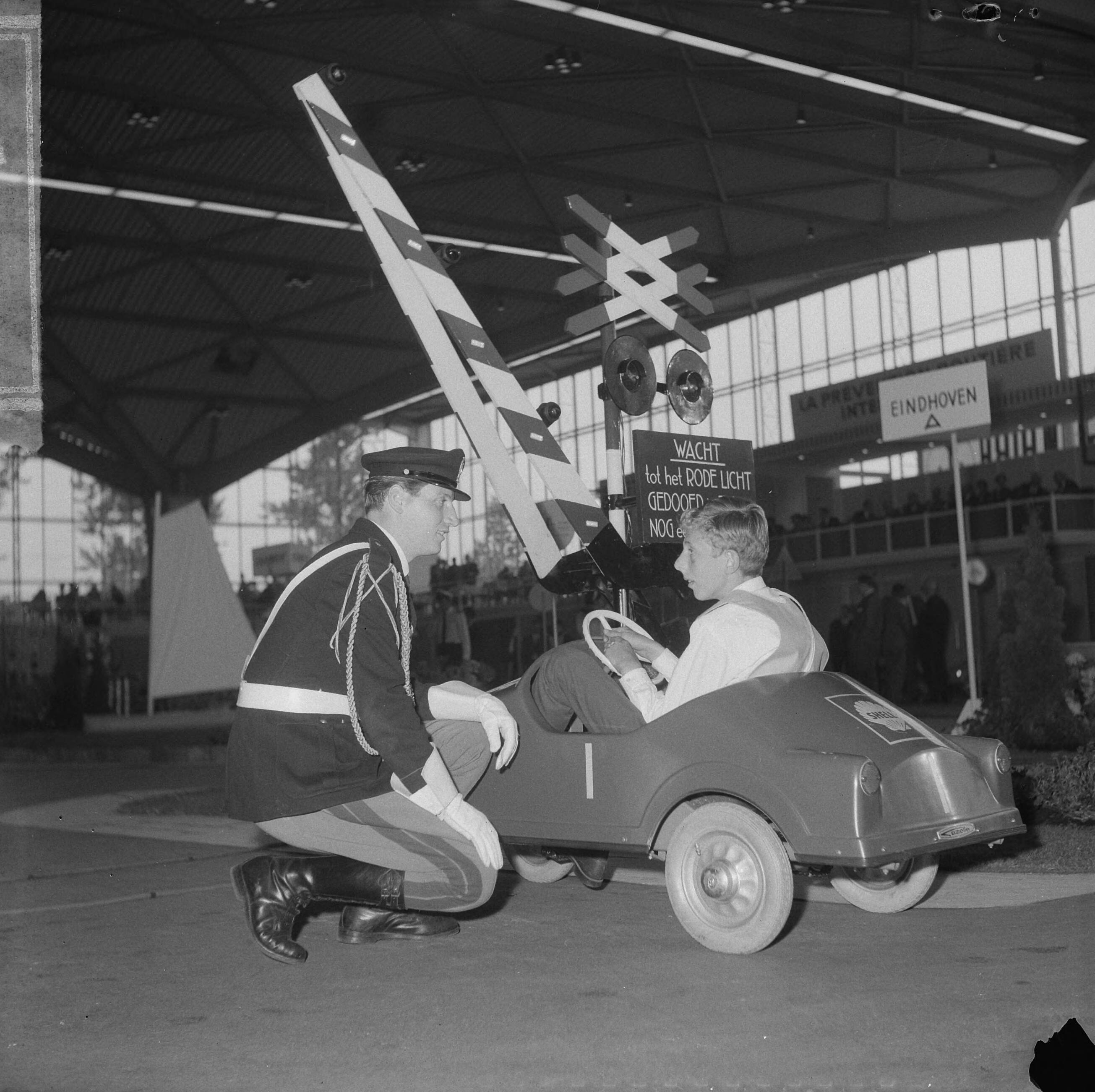 Fotocollectie Anefo — Internationale verkeerscompetitie in Expohal te Hilversum. een Italiaanse verkeersagent maakt de deelnemertjes een beetje wegwijs — Foto: Gelderen, Hugo van / Anefo. Licentie: Set B: Rechtenvrij / Publiek Domein. Bron: Nationaal Archief. http://hdl.handle.net/10648/aa6a2f90-d0b4-102d-bcf8-003048976d84