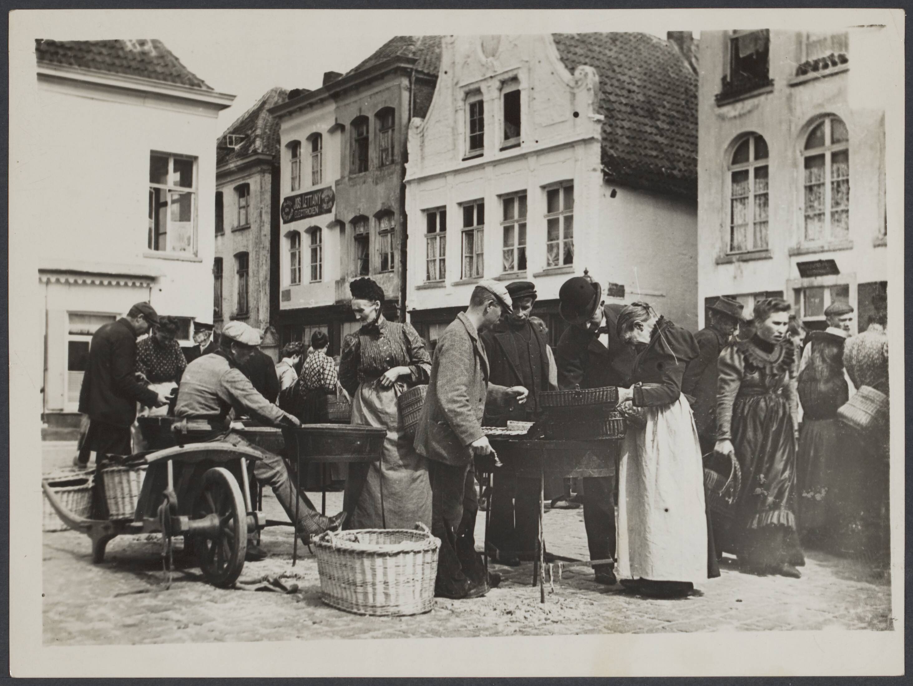 Mechelen — Mechelen. Palingverkopers met klanten op de Vismarkt — Foto: Onbekend / Publiek Domein of Rechtenvrij. Licentie: Set B: Rechtenvrij / Publiek Domein. Bron: Nationaal Archief. http://hdl.handle.net/10648/027db502-5a5a-e17b-83c0-fc662b5fe295