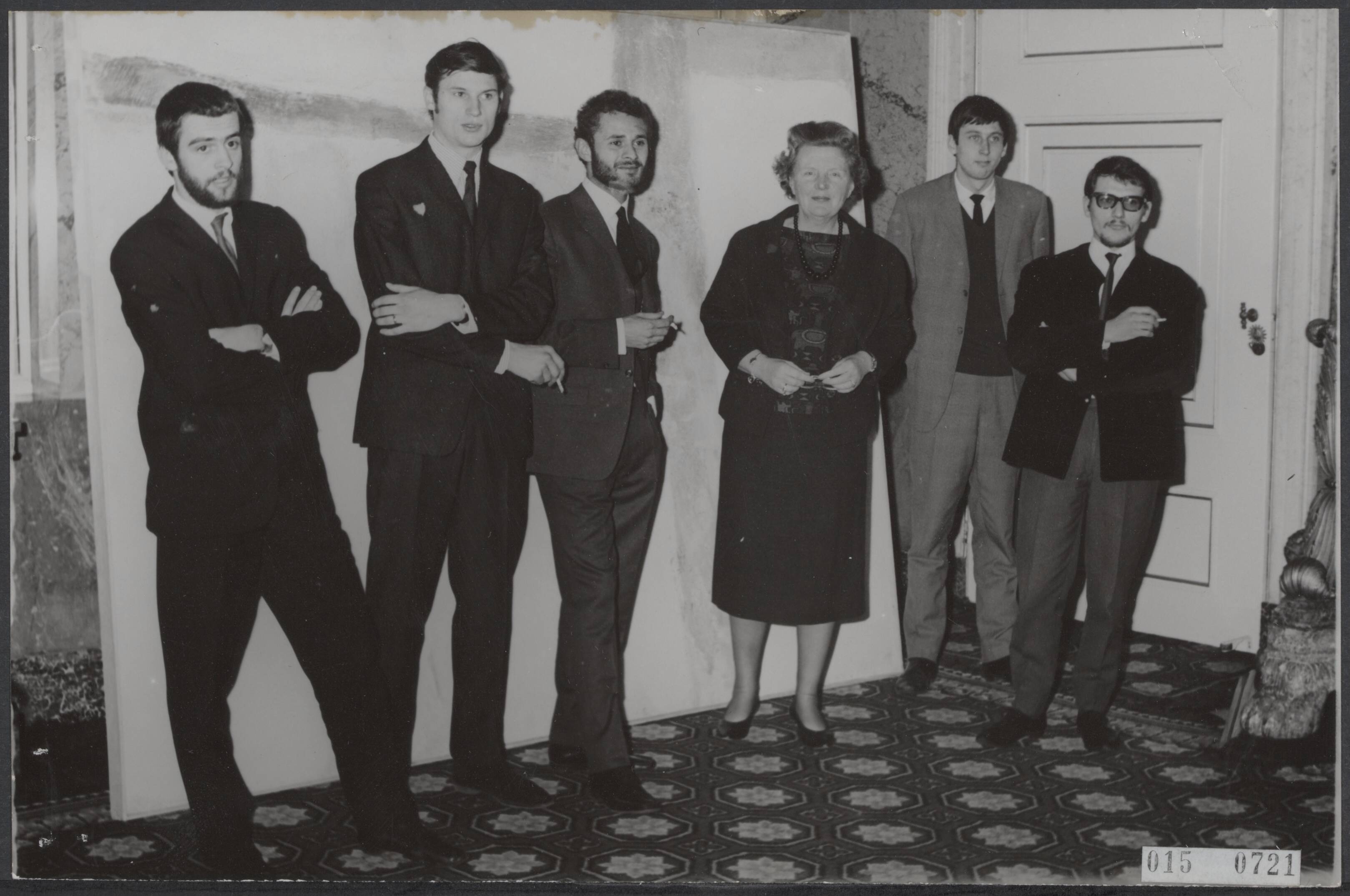 Fotocollectie Elsevier Binnenland — Koningin Juliana heeft op paleis Soestdijk vijf jonge kunstschilders ontvangen, waarvan het werk bekroond werd voor de Koninklijke Subsidie voor Vrije Schilderkunst 1963. Voor een van de bekroonde werken vlnr Pat Andrea, Gustave Asselbergs, Hans Hamers, koningin Juliana, Joop van Meel en A.C. Klop — Foto: Koch, Eric / Anefo. Licentie: Set B: Rechtenvrij / Publiek Domein. Bron: Nationaal Archief. http://hdl.handle.net/10648/adb5f1a2-d0b4-102d-bcf8-003048976d84