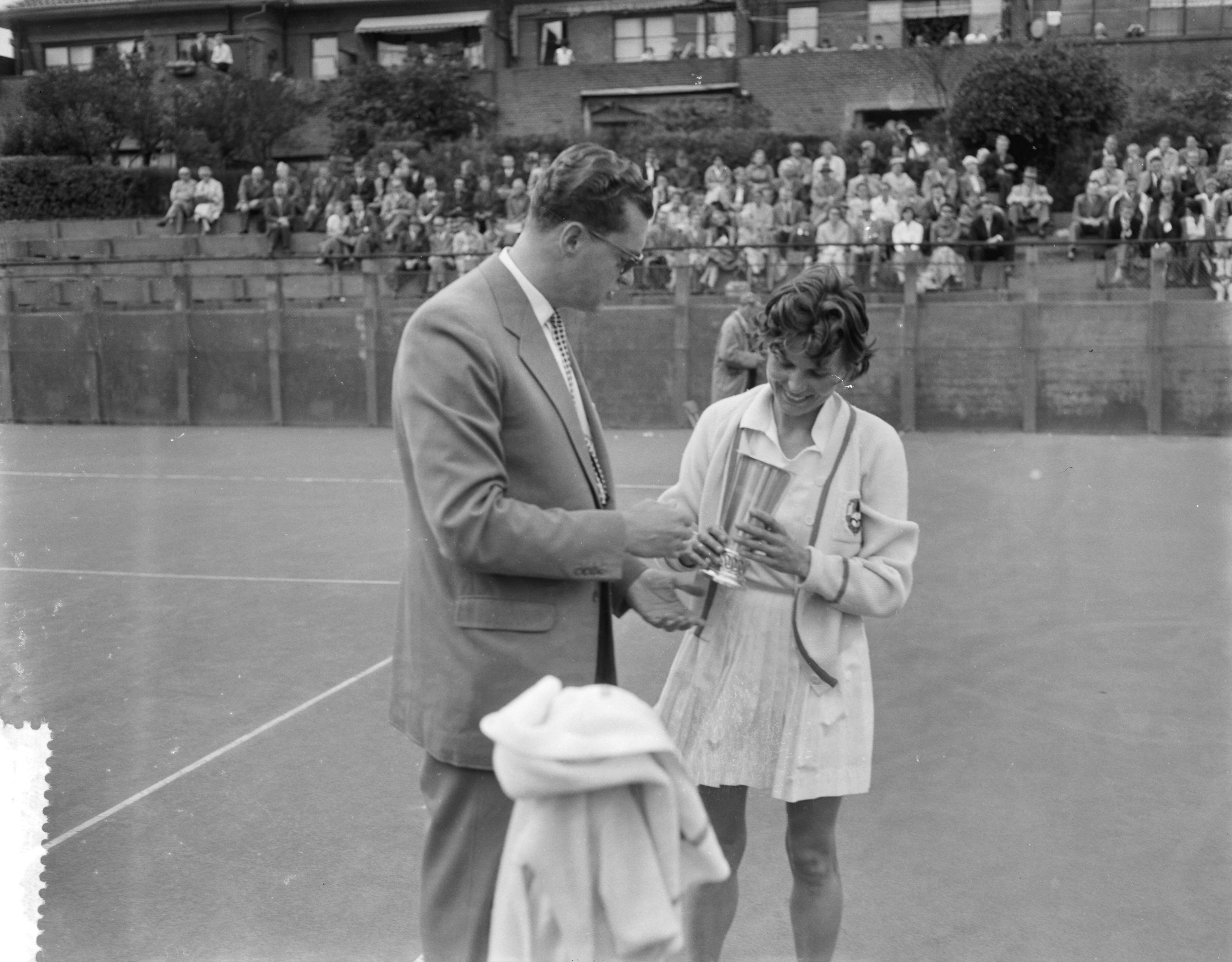 Fotocollectie Anefo — Nationale tenniskampioenschappen op de METS-banen. Kampioene enkelspel dames Francoise (Fransje) Rouwenhorst. Mr. H. Wilton (voorzitter KNLTB) reikte de beker uit — Foto: Rossem, Wim van / Anefo. Licentie: Set B: Rechtenvrij / Publiek Domein. Bron: Nationaal Archief. http://hdl.handle.net/10648/a967c9b8-d0b4-102d-bcf8-003048976d84