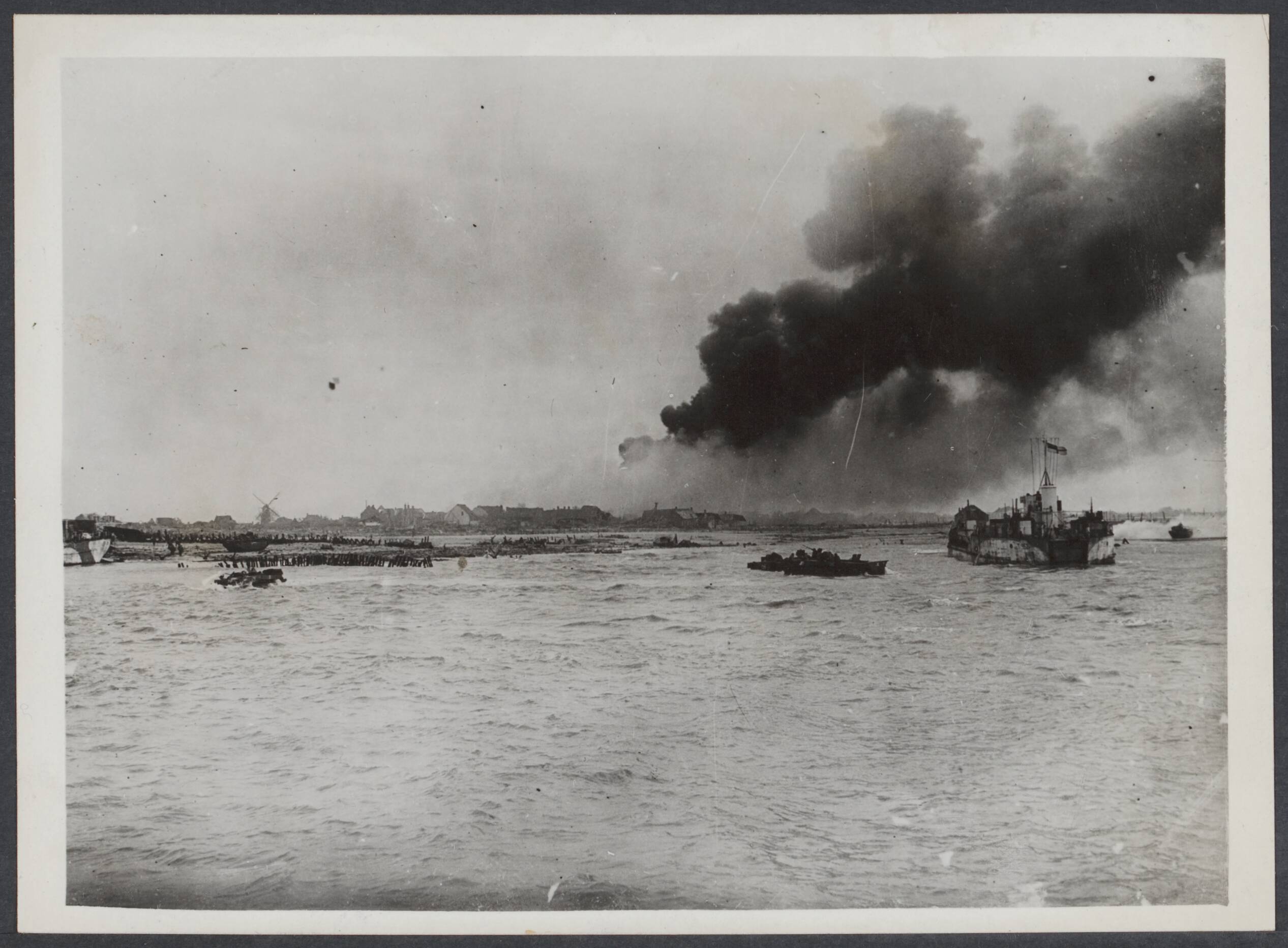 Westkapelle. Raid op de wijk van - 1944 — British Marine Commandos land on Walcheren at Westkapelle. Beachhead scene as tank landing craft approaches. Right background an enemy strongpoint on fire — Foto: Onbekend / Publiek Domein of Rechtenvrij. Licentie: Set B: Rechtenvrij / Publiek Domein. Bron: Nationaal Archief. http://hdl.handle.net/10648/c80cdc5f-bc69-bdaf-3fd3-f1bcfcb39fcb