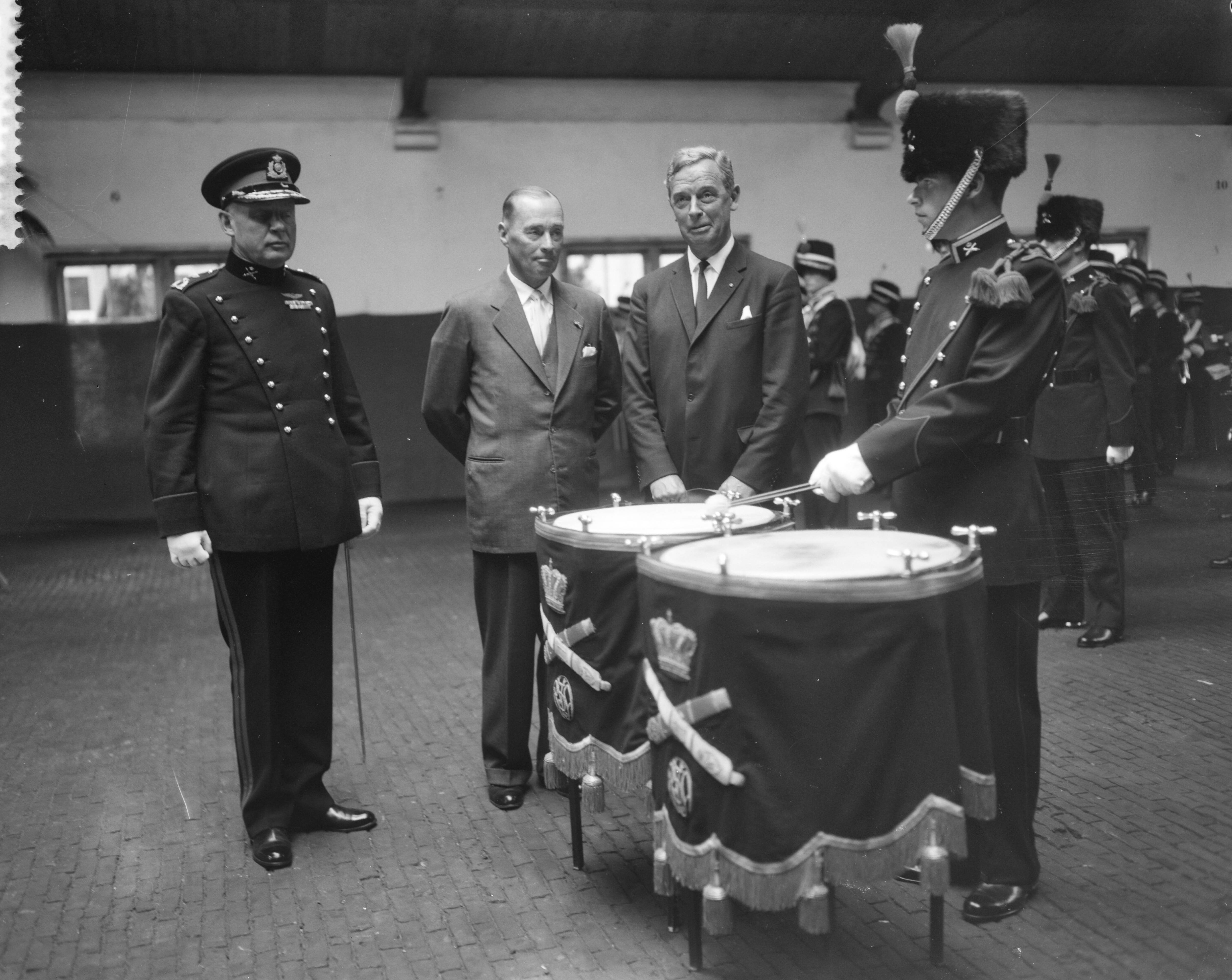 Fotocollectie Anefo — Symbolisch aanbieden van het ceremonieel tenue aan het trompetterkorps der artillerie in de Chassé-kazerne te Breda door de voorzitter van het comité "Muziek Artillerie", I.A. Aler aan de minister van Defensie, ir. S.H. Visser. Vlnr. generaal-majoor J.T. Winkel, I.A. Aler en minister Visser bij de twee pauken van het trompetterkorps — Foto: Bilsen, Joop van / Anefo. Licentie: Set B: Rechtenvrij / Publiek Domein. Bron: Nationaal Archief. http://hdl.handle.net/10648/a9b66ab4-d0b4-102d-bcf8-003048976d84