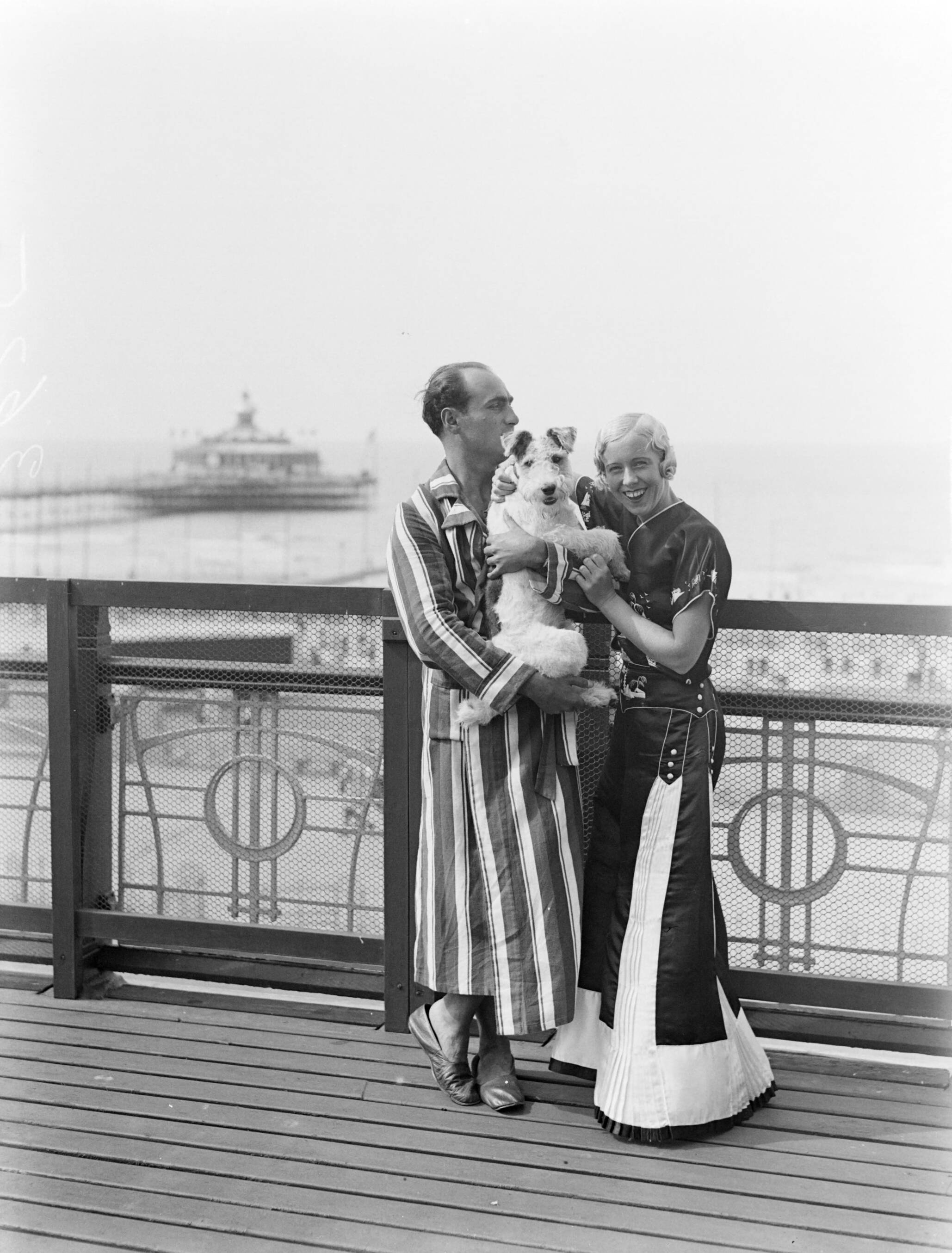 Scheveningen. — Een man (Farrar?) en een vrouw (Yvonne?) met een hond op het balkon van een hotelkamer van het Palace Hotel in Scheveningen — Foto: Poll, Willem van de. Licentie: Set B: Rechtenvrij / Publiek Domein. Bron: Nationaal Archief. http://hdl.handle.net/10648/ae9ab6c0-d0b4-102d-bcf8-003048976d84