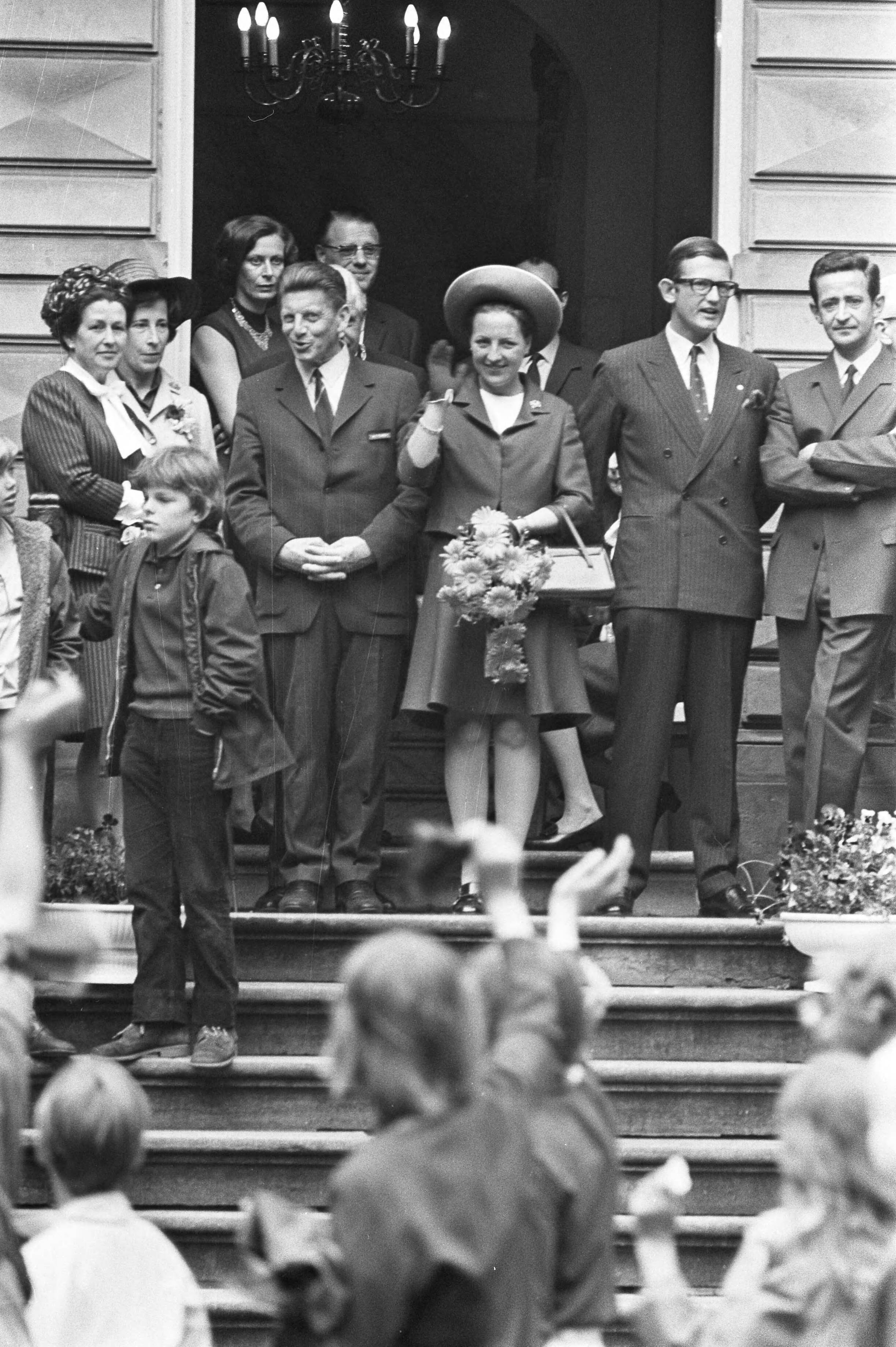 Prinses Margriet en mr. P. van Vollenhoven wonen Nationaal St. Joris marsen in Kasteel Oud Poelgeest in Oegstgeest bij — Zwaaiende prinses Margriet en Pieter van Vollenhoven op het bordes van kasteel Oud Poelgeest — Foto: Fotograaf Onbekend / Anefo. Licentie: Set B: Rechtenvrij / Publiek Domein. Bron: Nationaal Archief. http://hdl.handle.net/10648/abc061e8-d0b4-102d-bcf8-003048976d84