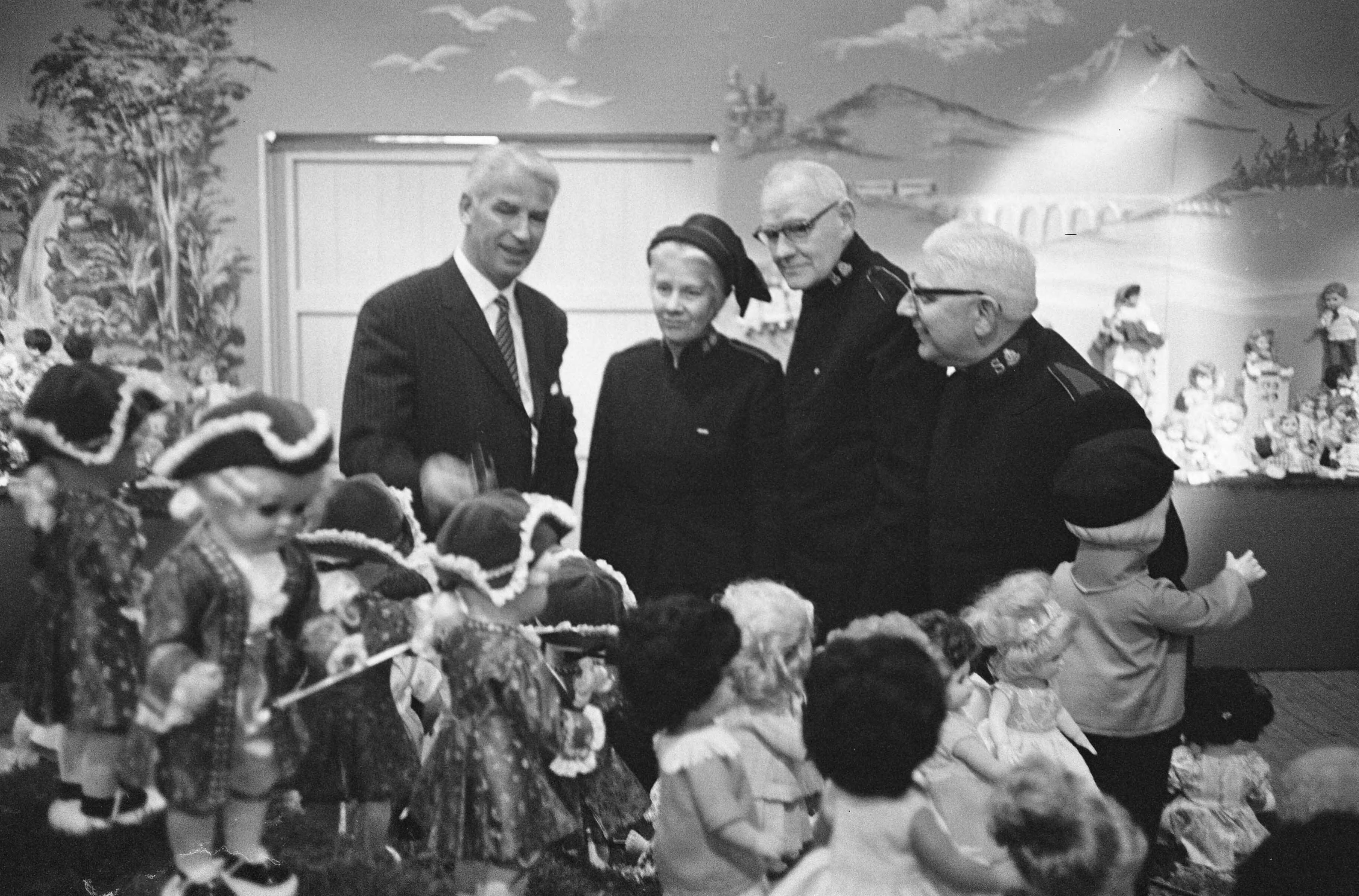 Fotocollectie Anefo — Albert Heijn N.V. in Zaandam heeft t.g.v. het 75-jarig bestaan aan haar vrienden en relaties gevraagd poppen te schenken i.p.v. de gebruikelijke cadeaus. Tijdens een receptie in Zaandam heeft de directie de poppen aan het Leger des Heils aangeboden — Foto: Pot, Harry / Anefo. Licentie: Set B: Rechtenvrij / Publiek Domein. Bron: Nationaal Archief. http://hdl.handle.net/10648/aa0a271c-d0b4-102d-bcf8-003048976d84