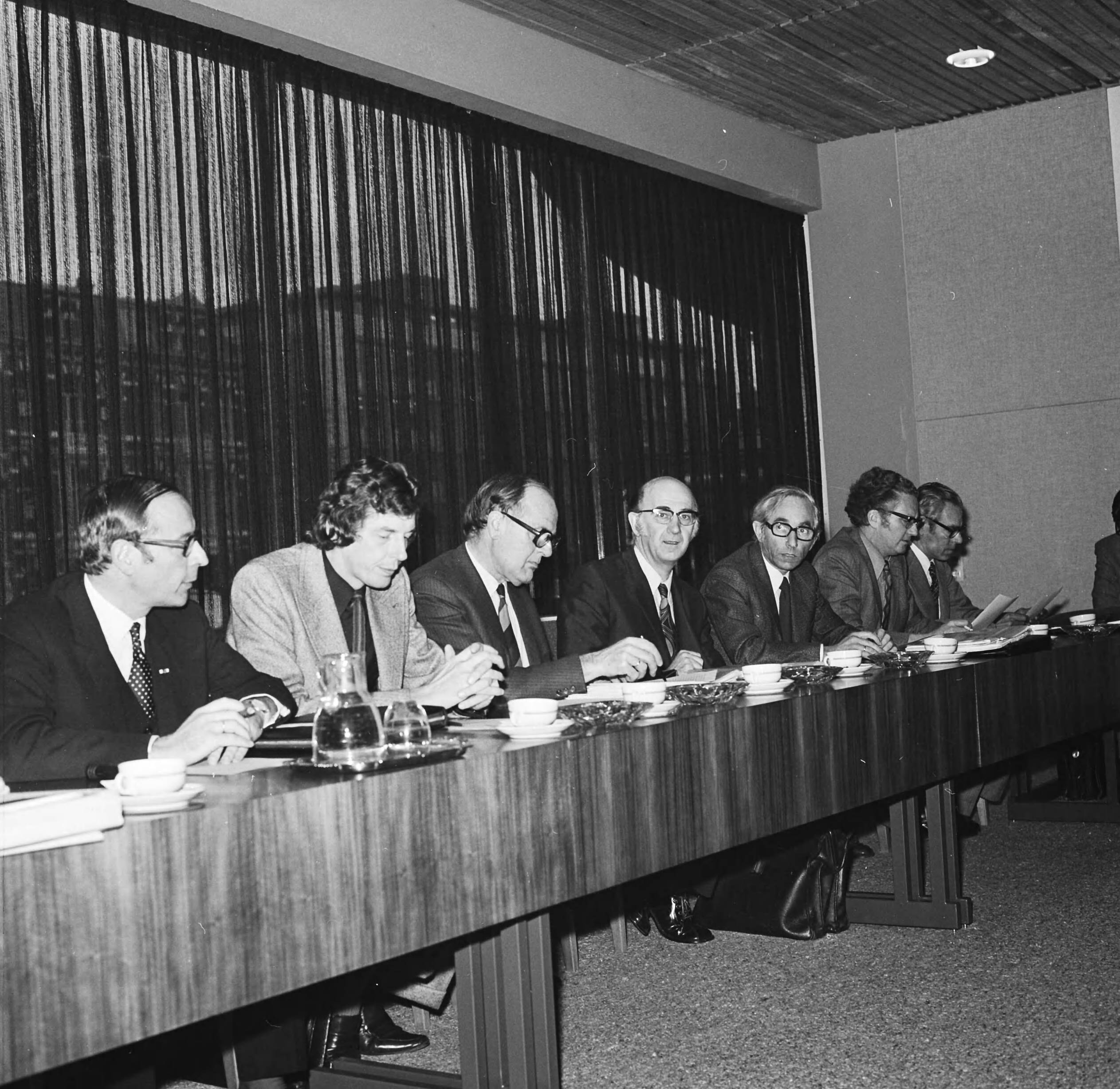 Loonoverleg tussen werknemers- en werkgeversorganisaties in Den Haag — Deelnemers aan het overleg aan de conferentietafel — Foto: Mieremet, Rob / Anefo. Licentie: Set B: Rechtenvrij / Publiek Domein. Bron: Nationaal Archief. http://hdl.handle.net/10648/ac3bbe88-d0b4-102d-bcf8-003048976d84
