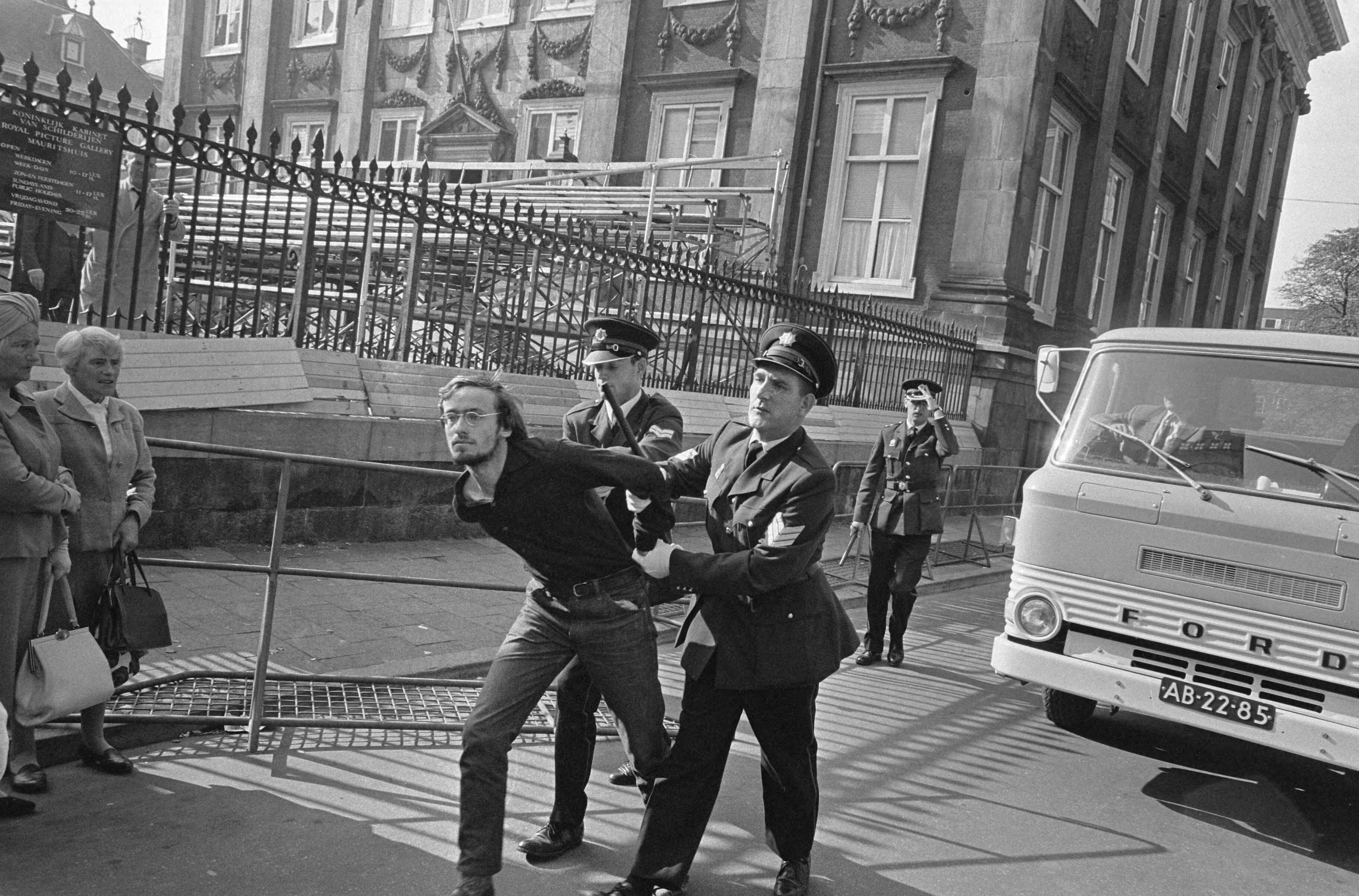 Protesterende Amsterdamse Provo's tijdens Prinsjesdag 1966 in Den Haag — Arrestatie van een lid van de Amsterdamse Provo (Hans Metz) — Foto: Fotograaf Onbekend / Anefo. Licentie: Set B: Rechtenvrij / Publiek Domein. Bron: Nationaal Archief. http://hdl.handle.net/10648/aafd41f4-d0b4-102d-bcf8-003048976d84