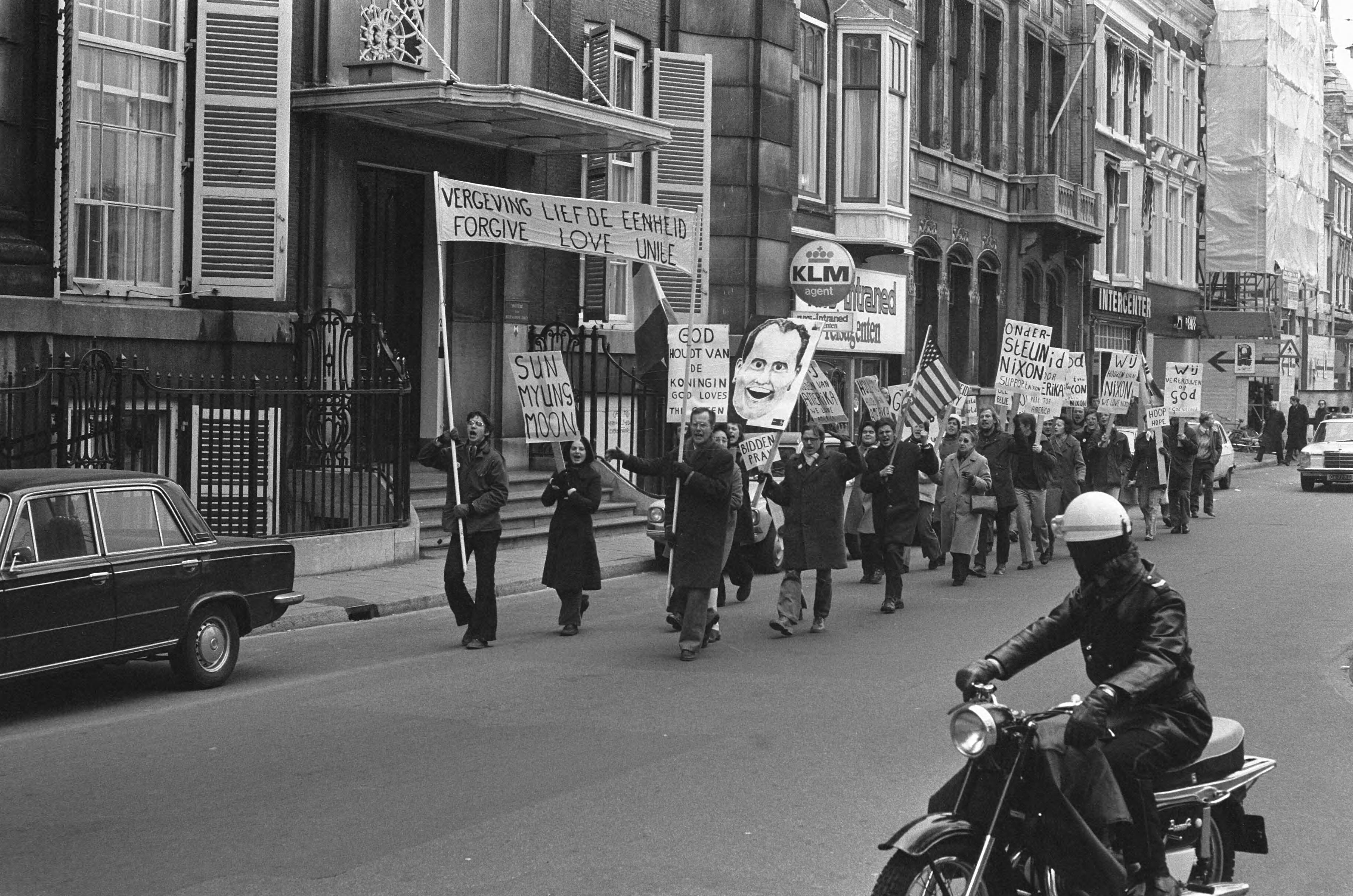 Aanhangers van Sun Myung Moon demonstreren in Den Haag o.a. pro-Nixon — De betogers met spandoeken — Foto: Fotograaf Onbekend / Anefo. Licentie: Set B: Rechtenvrij / Publiek Domein. Bron: Nationaal Archief. http://hdl.handle.net/10648/ac43fa80-d0b4-102d-bcf8-003048976d84