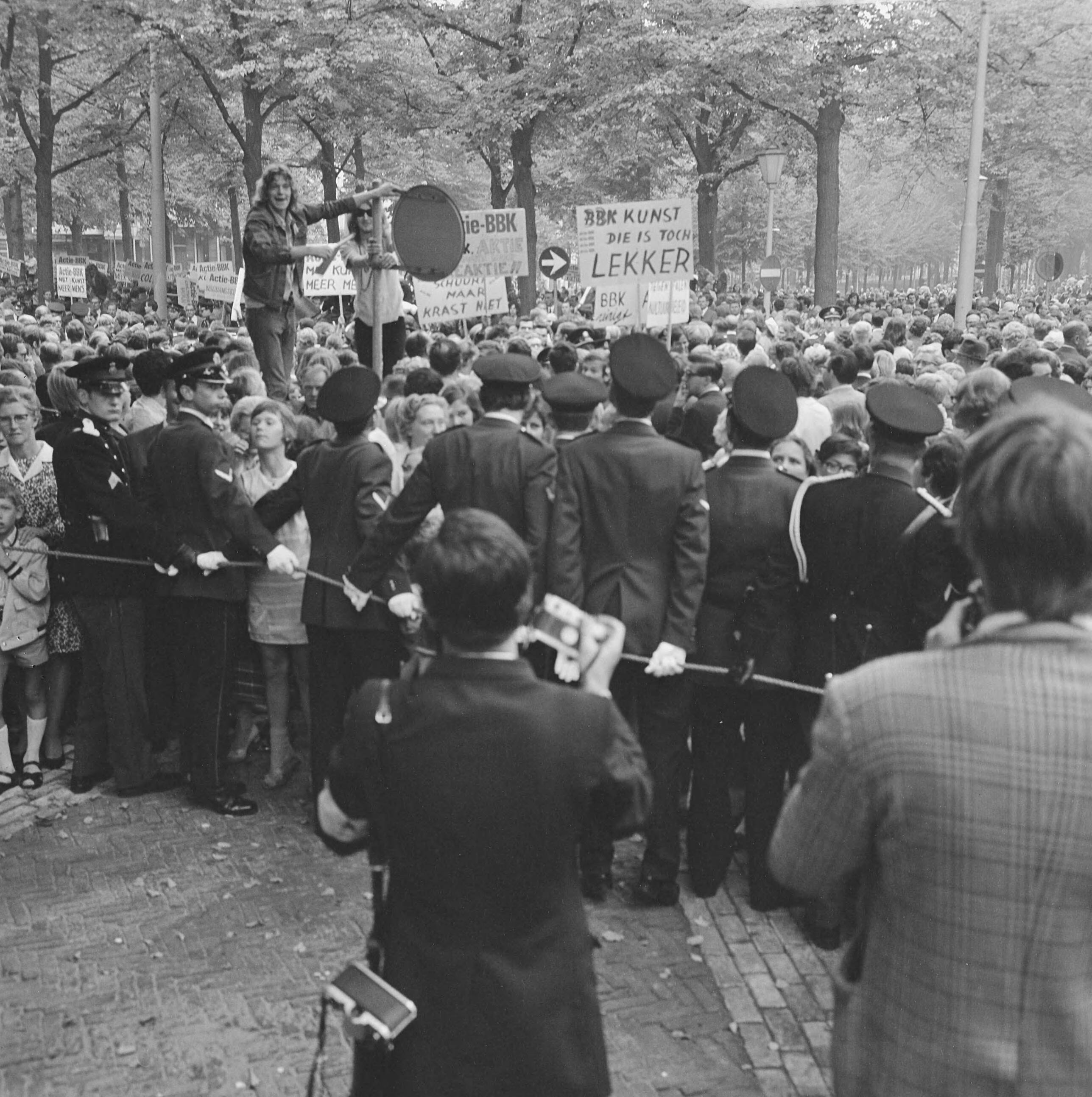Fotocollectie Anefo — Kunstenaars van de BBK protesteren met borden tegen het cultuurbeleid op Lange Voorhout Den Haag tijdens rit Kon. Fam. naar Pal. Lange Voorhout : demonstrerende — Foto: Koch, Eric / Anefo. Licentie: Set B: Rechtenvrij / Publiek Domein. Bron: Nationaal Archief. http://hdl.handle.net/10648/ab7a02fc-d0b4-102d-bcf8-003048976d84