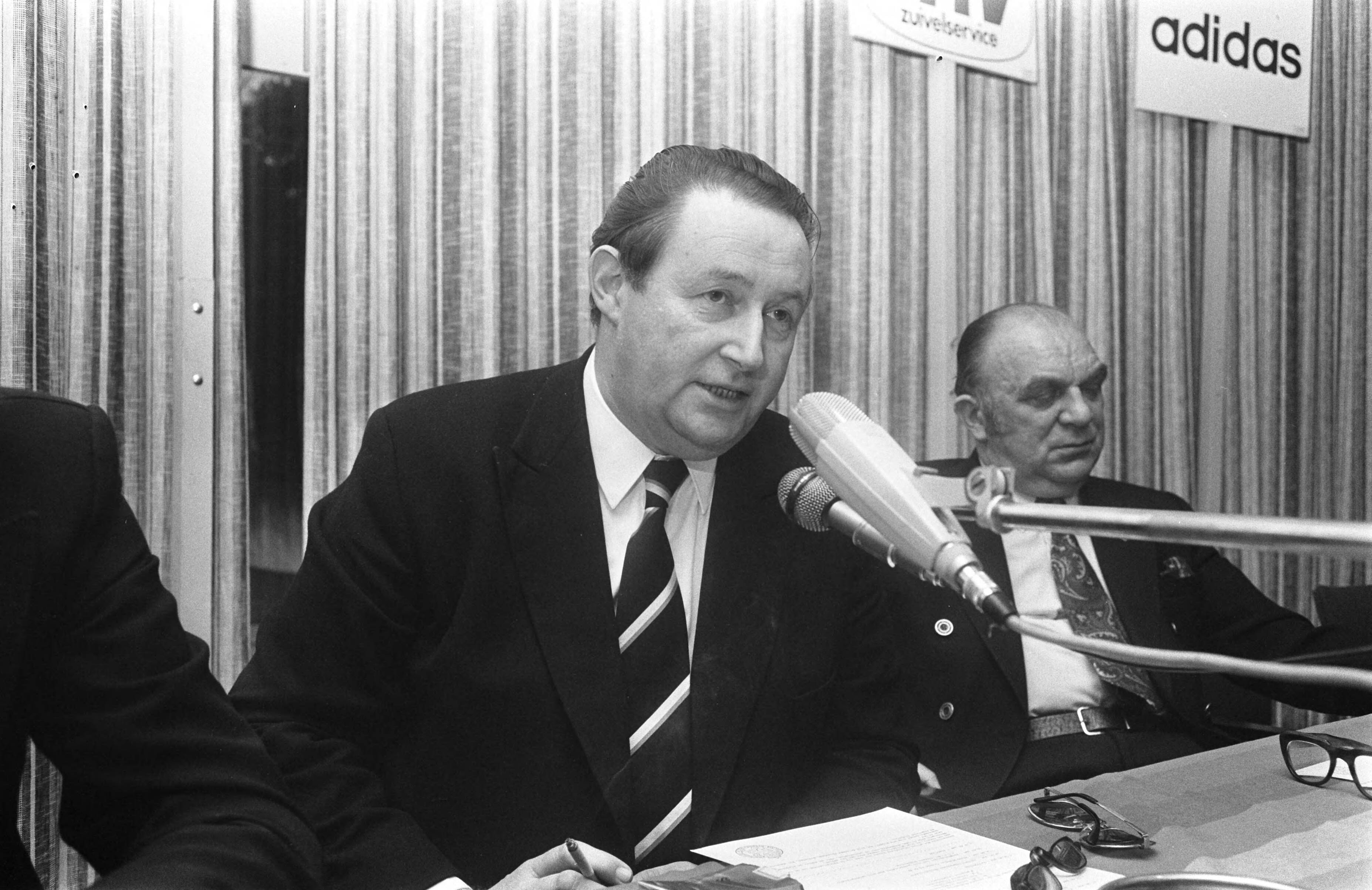 Rinus Michels, supervisor van het Nederlands elftal bij het WK voetbal in 1974 geeft een persconferentie in het KNVB-centrum te Zeist — KNVB bestuurslid Zwikstra en rechts Van Zon — Foto: Fotograaf Onbekend / Anefo. Licentie: Set B: Rechtenvrij / Publiek Domein. Bron: Nationaal Archief. http://hdl.handle.net/10648/ac42ceda-d0b4-102d-bcf8-003048976d84