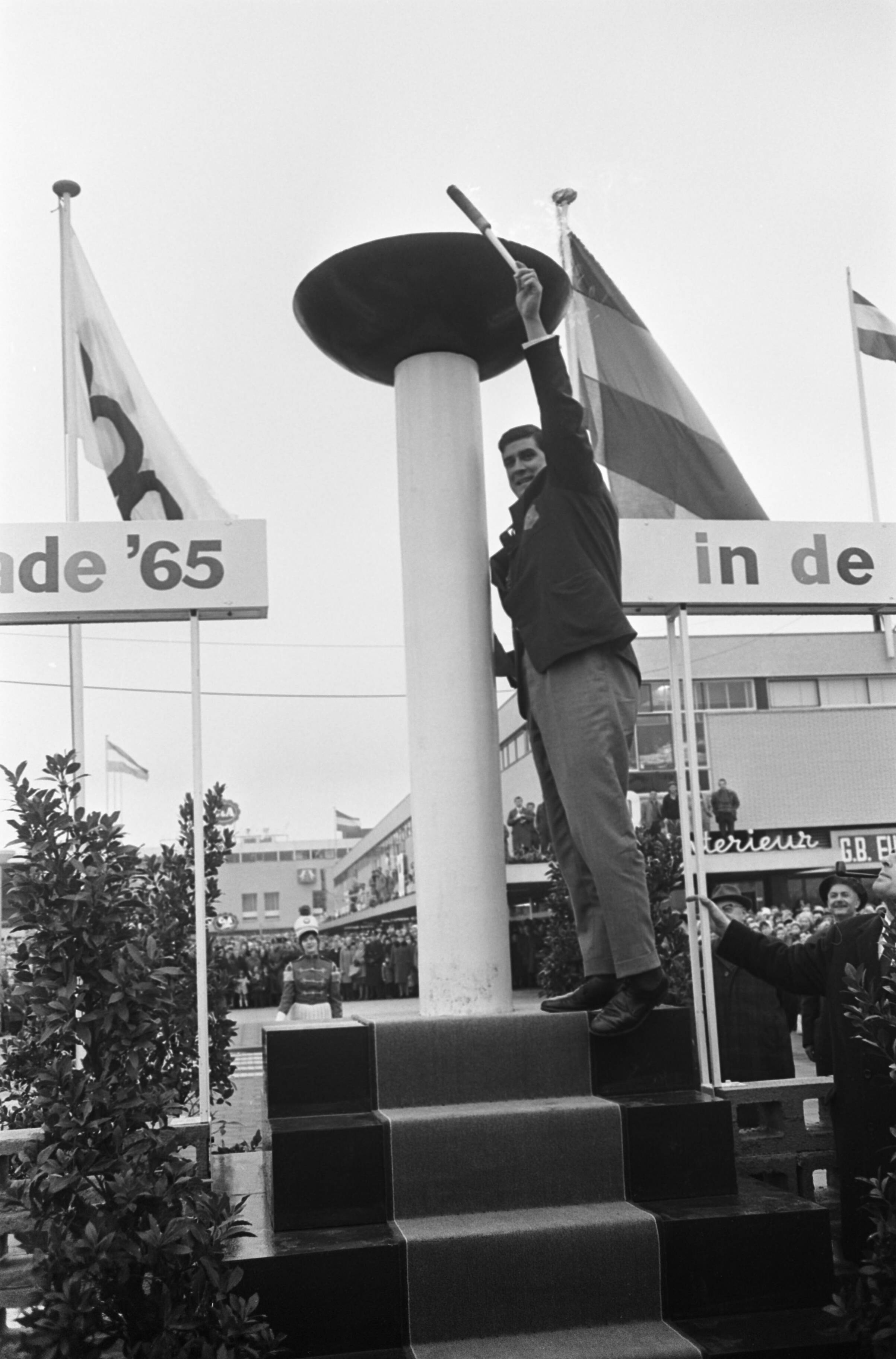 Fotocollectie Anefo — Anton Geesink bij opening nieuwe winkel C & A te Rijswijk, Anton Geesink ontsteekt het vuur met een fakkel — Foto: Koch, Eric / Anefo. Licentie: Set B: Rechtenvrij / Publiek Domein. Bron: Nationaal Archief. http://hdl.handle.net/10648/aa9adb90-d0b4-102d-bcf8-003048976d84