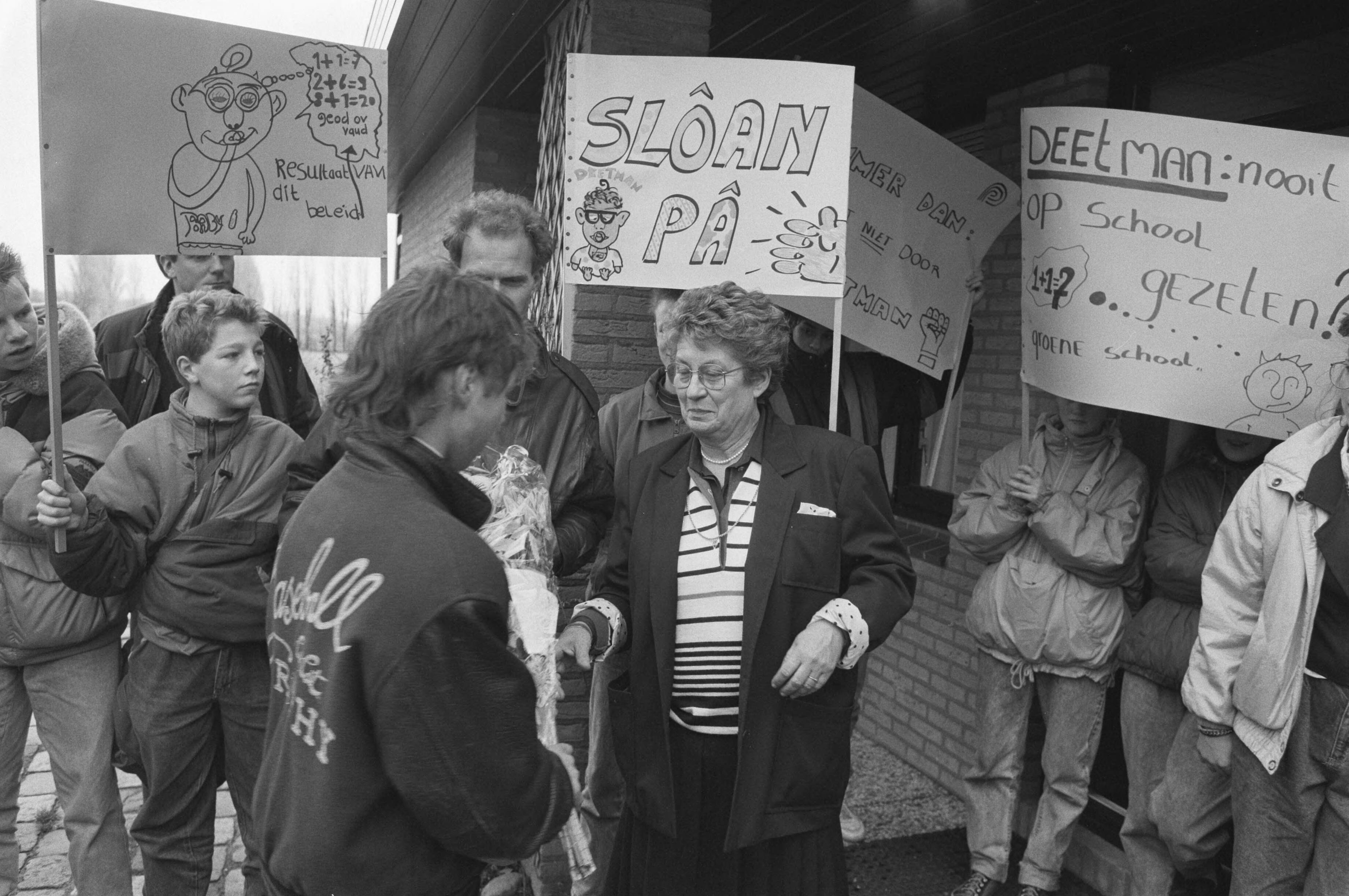 Fotocollectie Anefo — Landelijke actiedag tegen bezuinigingen op basis en voortgezet onderwijs; leerl. brengen staatssecr Ginjaar Maas grafkrans in Leidschendam — Foto: Bogaerts, Rob / Anefo. Licentie: Set B: Rechtenvrij / Publiek Domein. Bron: Nationaal Archief. http://hdl.handle.net/10648/ad6f28e4-d0b4-102d-bcf8-003048976d84