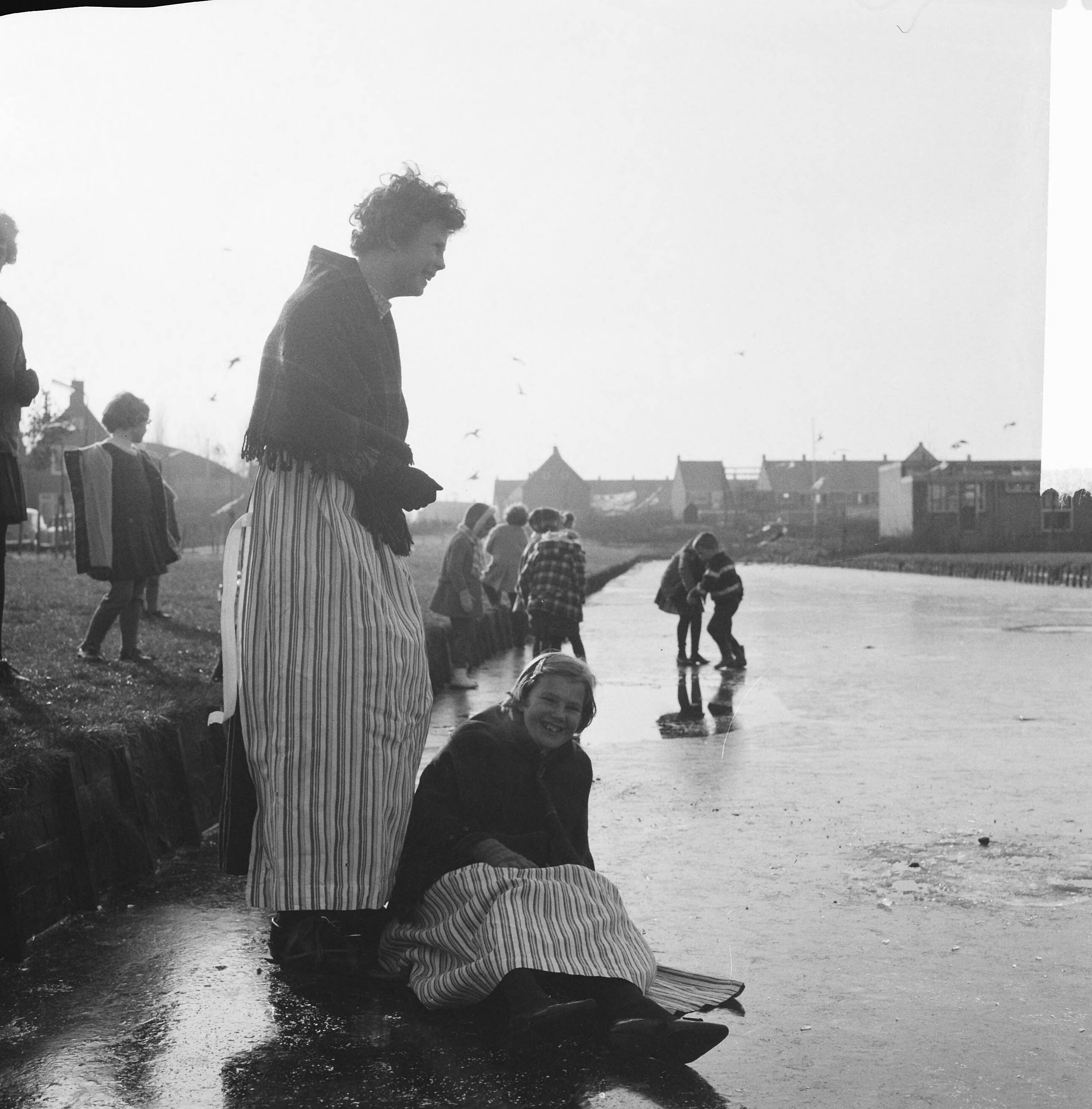 IJspret in Volendam — Meisjes in klederdracht op het ijs in Volendam — Foto: Kroon, Ron / Anefo. Licentie: Set B: Rechtenvrij / Publiek Domein. Bron: Nationaal Archief. http://hdl.handle.net/10648/aace07ea-d0b4-102d-bcf8-003048976d84