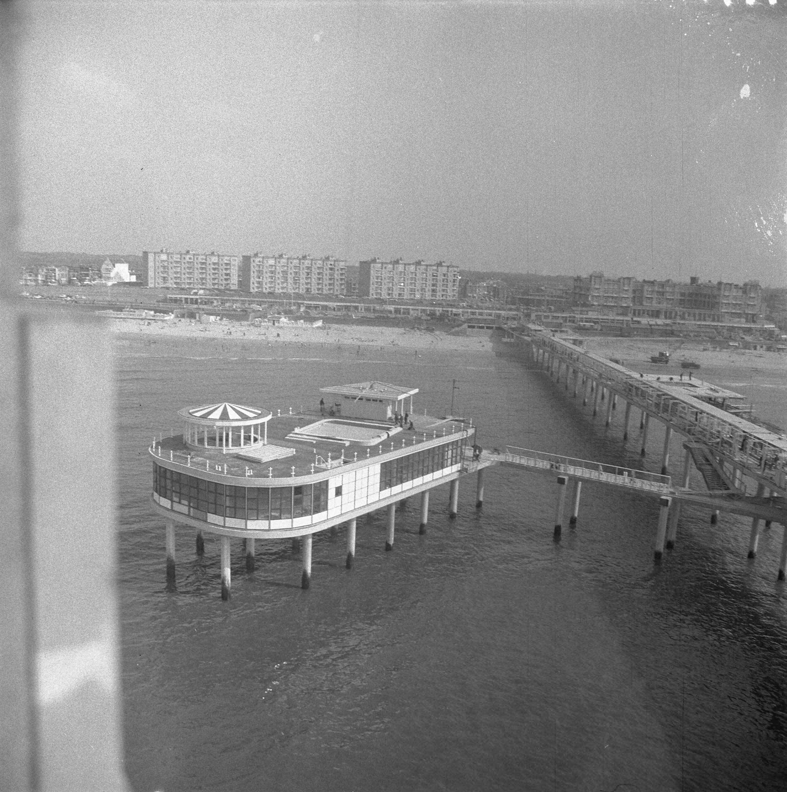 Fotocollectie Anefo — Werkzaamheden Pier te Scheveningen. Overzicht Pier naar het strand — Foto: Nijs, Jac. de / Anefo. Licentie: Set B: Rechtenvrij / Publiek Domein. Bron: Nationaal Archief. http://hdl.handle.net/10648/a9d0f4b0-d0b4-102d-bcf8-003048976d84