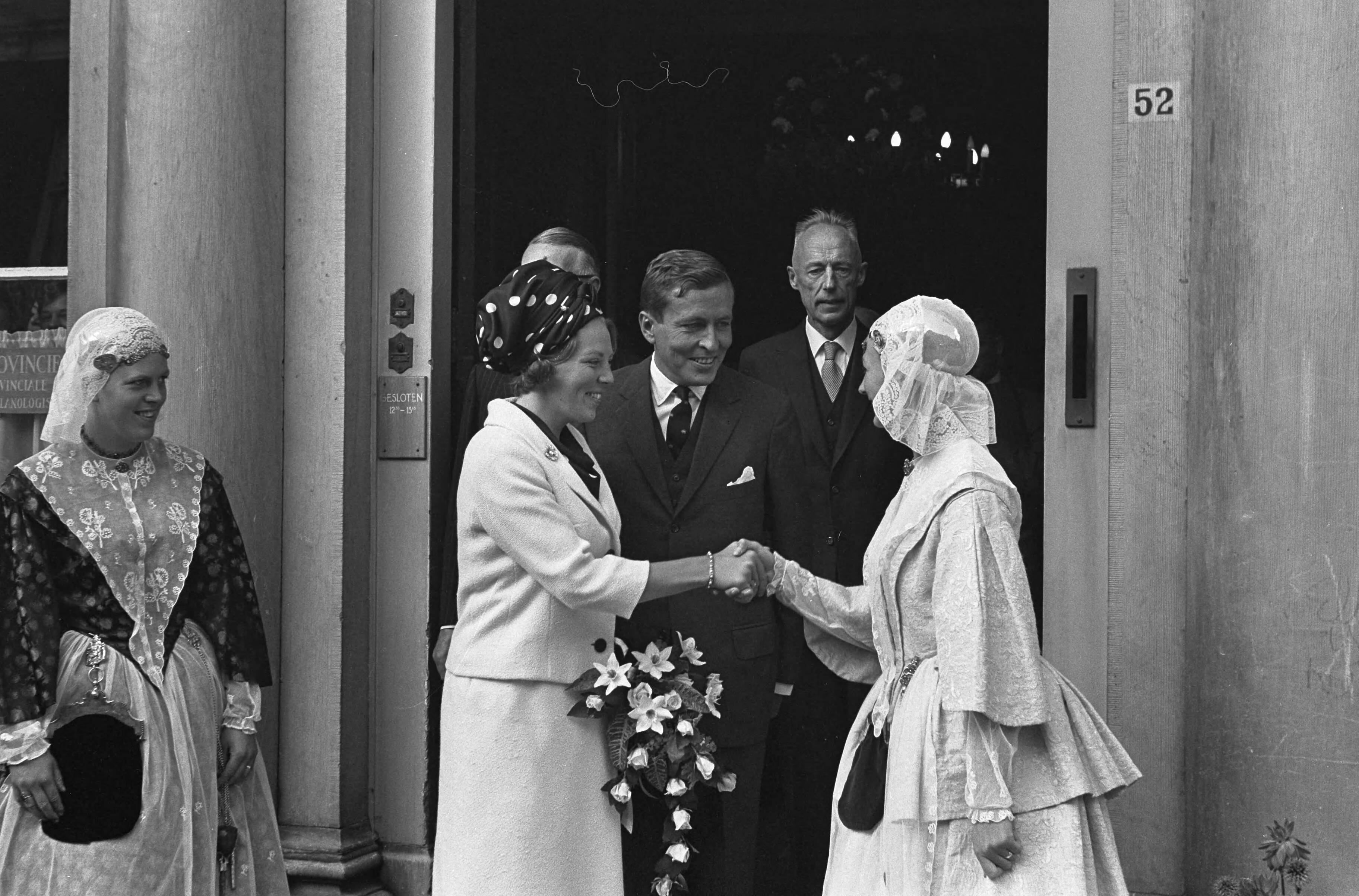 Bezoek van prinses Beatrix en Claus von Amsberg aan de drie noordelijke provincies — Bezoek prinses Beatrix en haar verloofde Claus von Amsberg aan Leeuwarden, het paar bij het Provinciehuis, het paar wordt voorgesteld aan twee meisjes in Friese klederdracht — Foto: Evers, Joost / Anefo. Licentie: Set B: Rechtenvrij / Publiek Domein. Bron: Nationaal Archief. http://hdl.handle.net/10648/aabef8b8-d0b4-102d-bcf8-003048976d84
