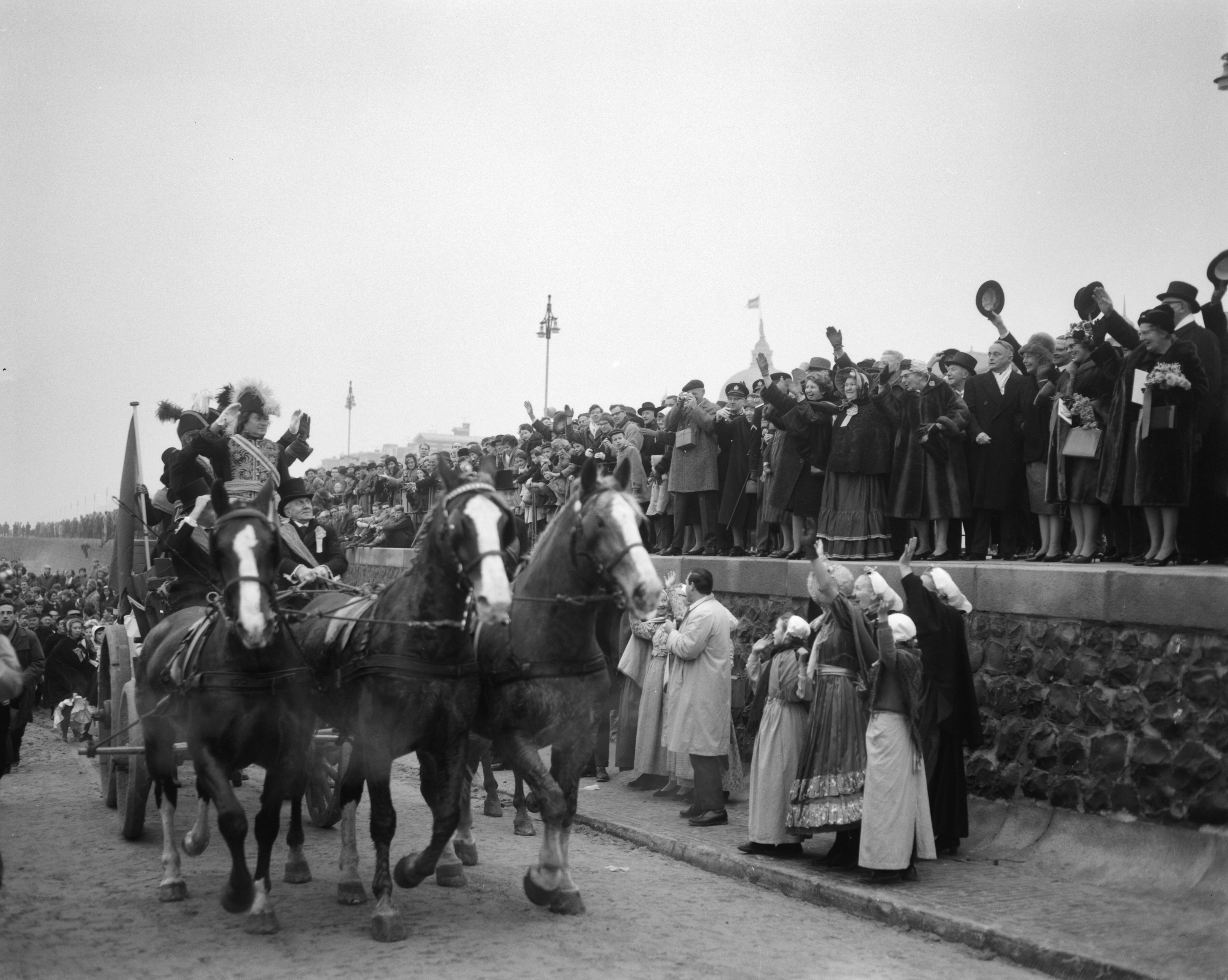 Fotocollectie Anefo — Te Scheveningen is de landing en intocht van prins Willem Frederik in 1813 herdacht. Op een nettenwagen begon de prins zijn intocht. Rechts tussen publiek prinses Beatrix en koningin Juliana. In het midden Commissaris der Koningin in Zuid-Holland, mr. J. Klaasesz — Foto: Bilsen, Joop van / Anefo. Licentie: Set B: Rechtenvrij / Publiek Domein. Bron: Nationaal Archief. http://hdl.handle.net/10648/aa500dd6-d0b4-102d-bcf8-003048976d84