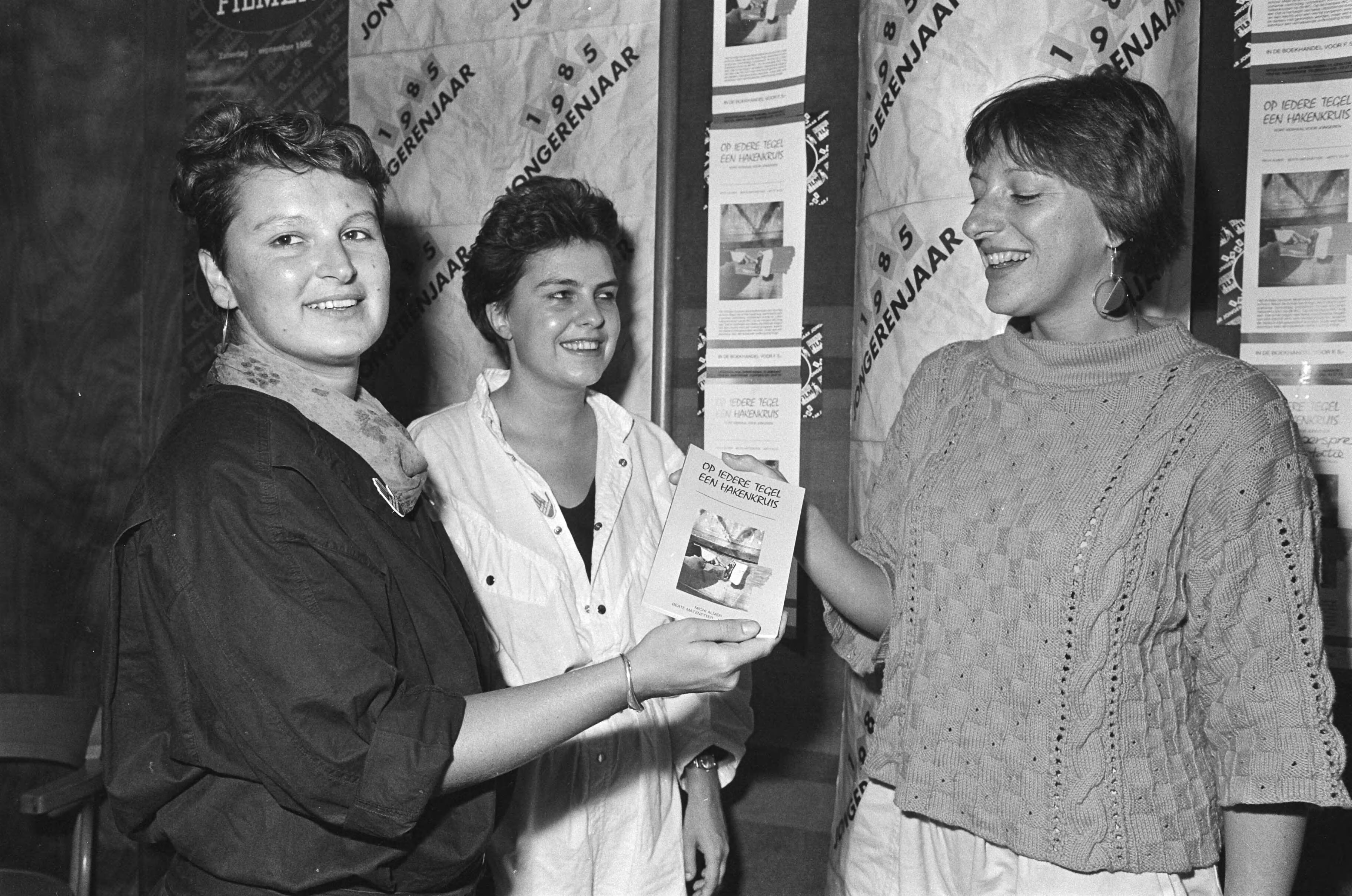 Fotocollectie Anefo — Jongerenmanifestatie Rianne Roding (jongeren tegen racisme) krijgt het boekje "Op ieder tegel een hakenkruis" door twee schrijfsters — Foto: Vollebregt, Sjakkelien / Anefo. Licentie: Set B: Rechtenvrij / Publiek Domein. Bron: Nationaal Archief. http://hdl.handle.net/10648/ad4aa96a-d0b4-102d-bcf8-003048976d84
