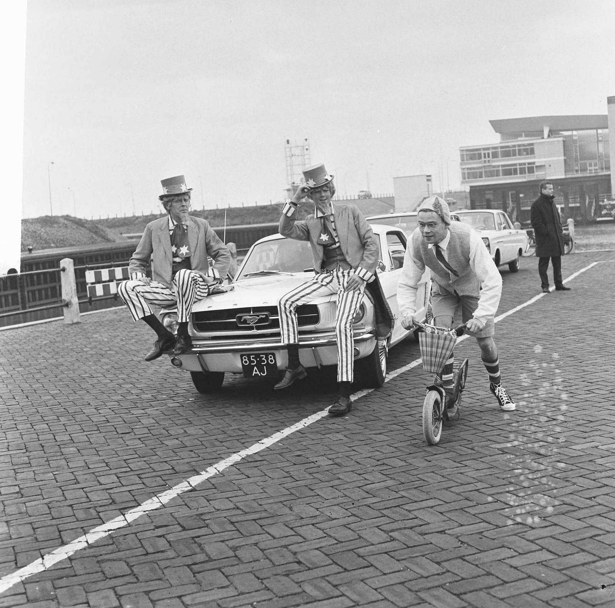 Fotocollectie Anefo — Kruik boegwater van radioschip Veronica, op autopeds als estafette naar Utrecht gebracht door studenten, Uncle Sam ging per auto, een student uit estafetteploeg per — Foto: Kroon, Ron / Anefo. Licentie: Set B: Rechtenvrij / Publiek Domein. Bron: Nationaal Archief. http://hdl.handle.net/10648/aad9efc4-d0b4-102d-bcf8-003048976d84