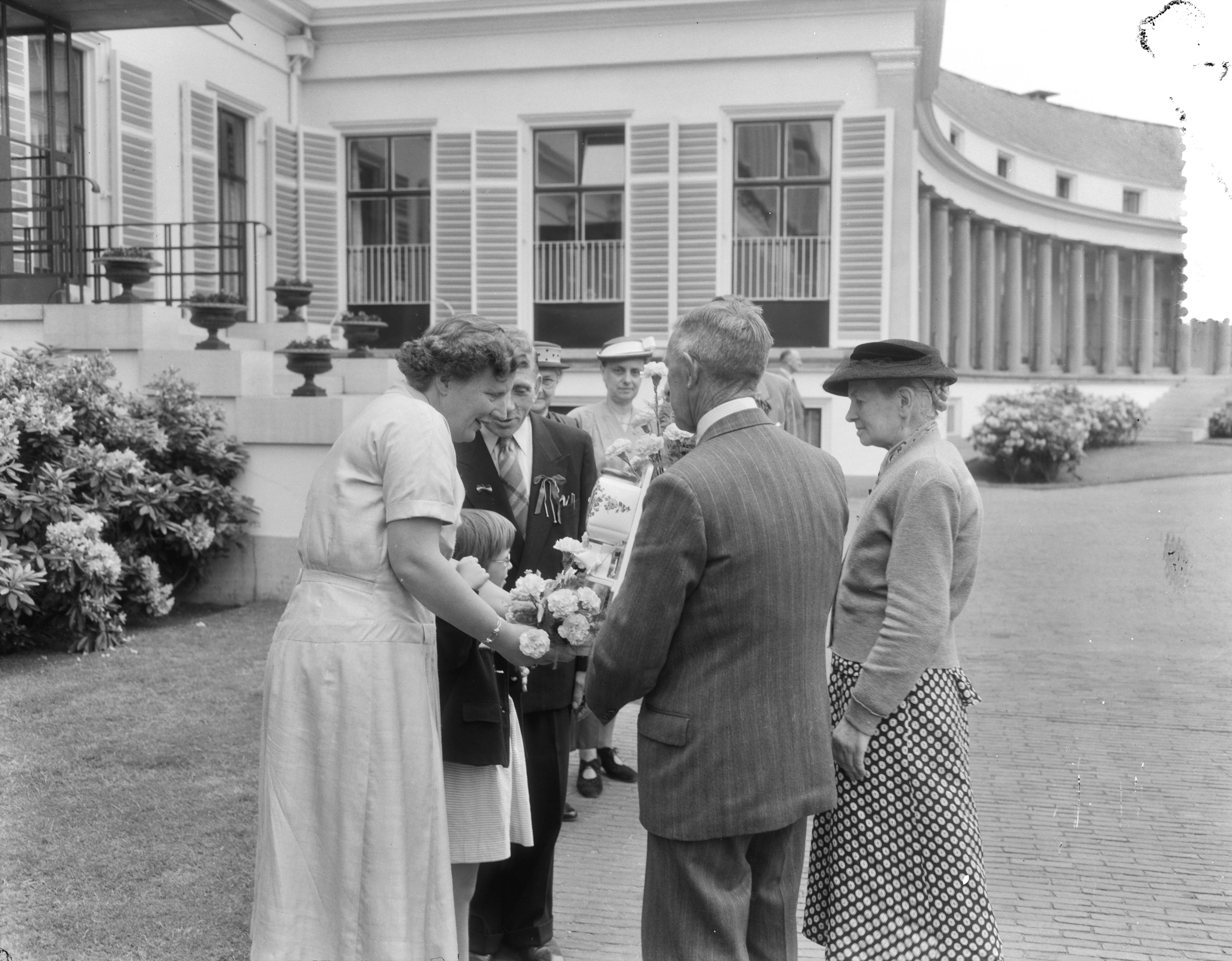 Fotocollectie Anefo — Ontvangst van bejaarden uit Gramsbergen, Breukelen en Fijnaart op paleis Soestdijk door koningin Juliana in aanwezigheid van prinses Margriet en prinses Marijke (Christina). Michiel van Muiswinkel en Johanna van Muiswinkel-van Zwieten bieden een koffiemolen aan. — Foto: Duinen, G.W. van / Anefo. Licentie: Set B: Rechtenvrij / Publiek Domein. Bron: Nationaal Archief. http://hdl.handle.net/10648/a92429f6-d0b4-102d-bcf8-003048976d84