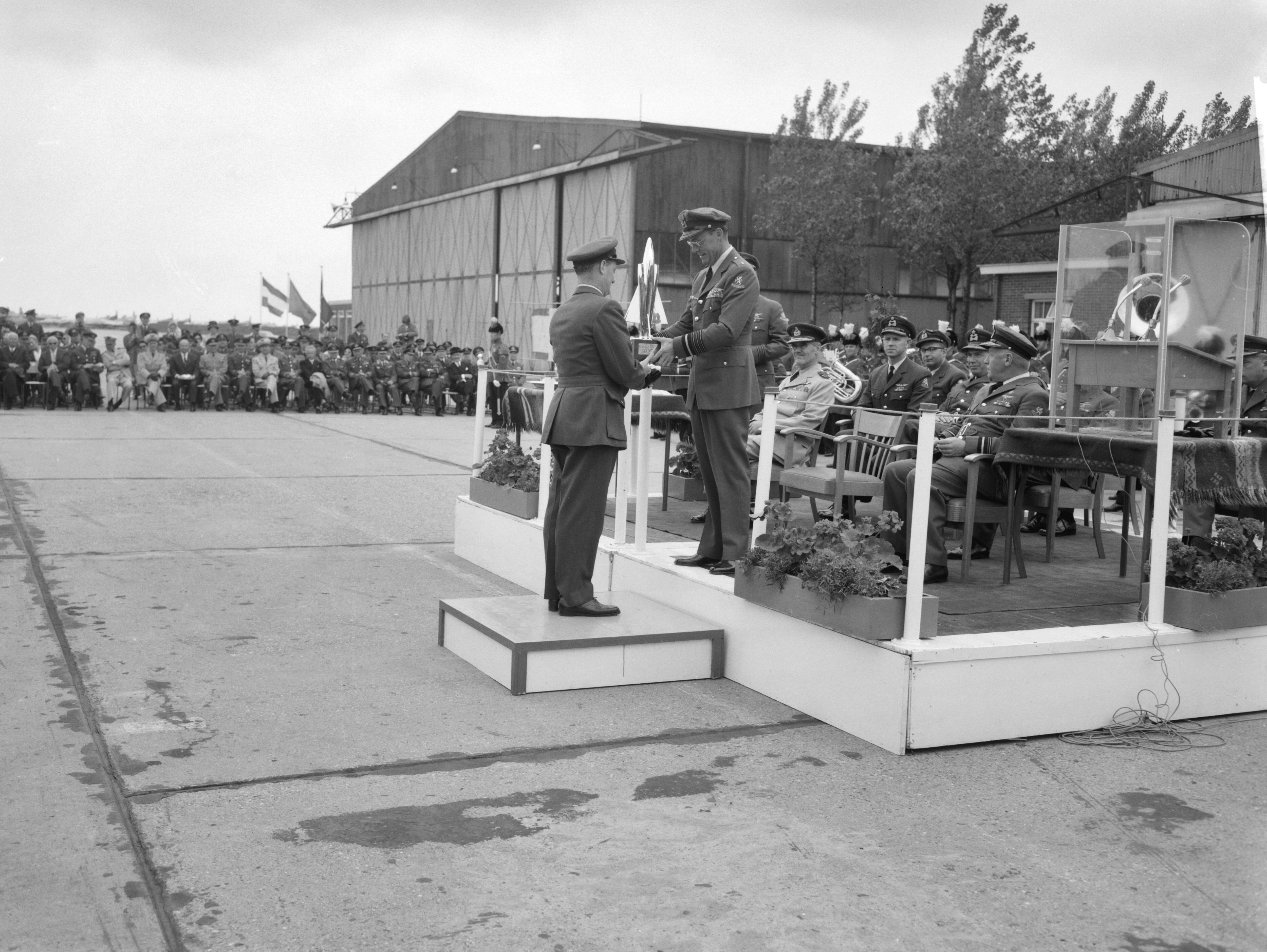 Fotocollectie Anefo — Prins Bernhard reikt in Leeuwarden prijzen uit van 5e Aircent-schietcompetitie van de NAVO luchtmacht. Brian Mercer "squadron-leader" van de winnende Britse ploeg ontving uit handen van de prins de Guynemertrofee — Foto: Bilsen, Joop van / Anefo. Licentie: Set B: Rechtenvrij / Publiek Domein. Bron: Nationaal Archief. http://hdl.handle.net/10648/aa0d622e-d0b4-102d-bcf8-003048976d84