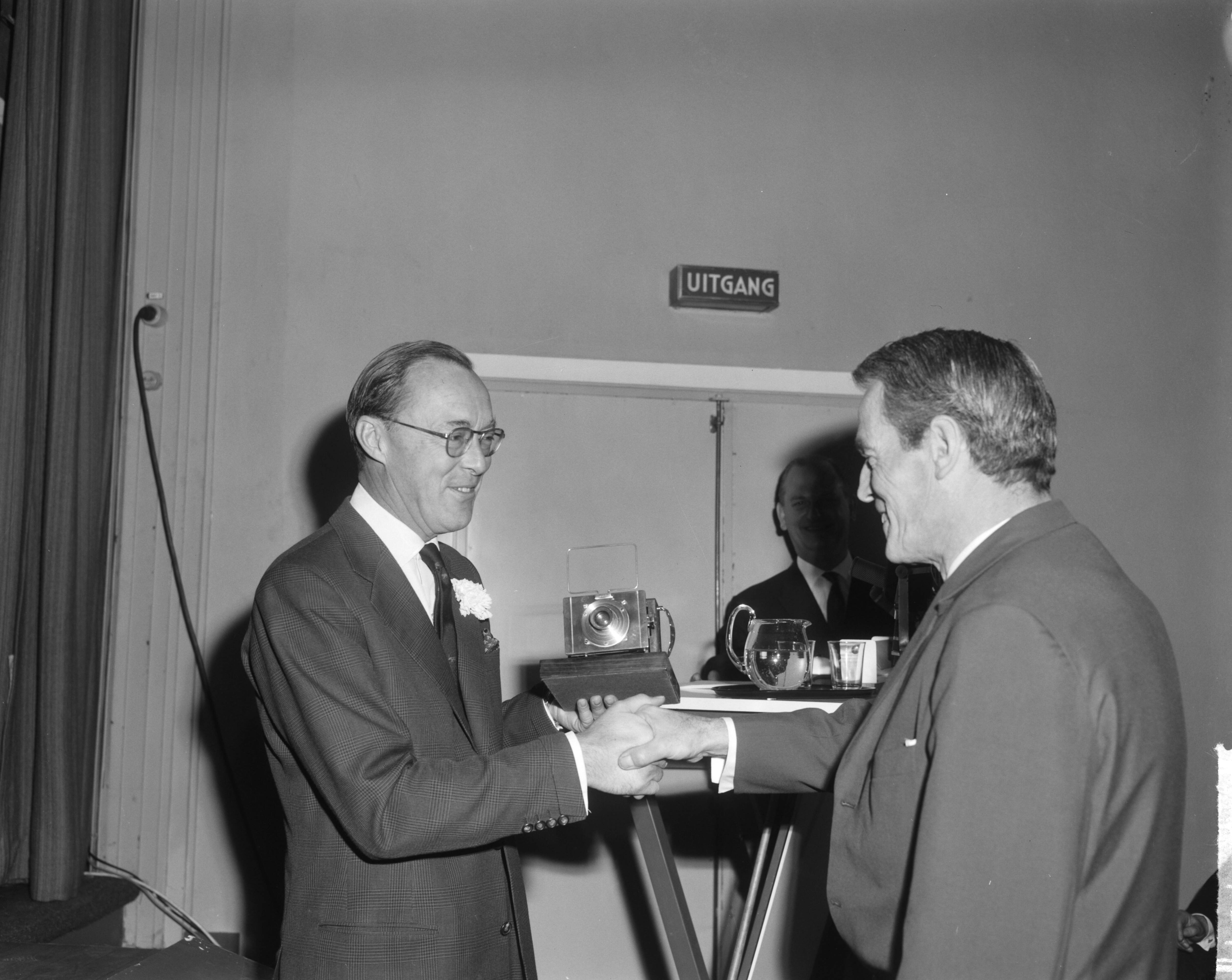 Fotocollectie Anefo — Prins Bernhard opende tentoonsteling World Press Photo 1963 in het Gemeentemuseum te Den Haag. De prins feliciteert de winnaar van de Zilveren Camera, de Nederlandse fotograaf Co Zeylemaker — Foto: Bilsen, Joop van / Anefo. Licentie: Set B: Rechtenvrij / Publiek Domein. Bron: Nationaal Archief. http://hdl.handle.net/10648/aa5205f0-d0b4-102d-bcf8-003048976d84