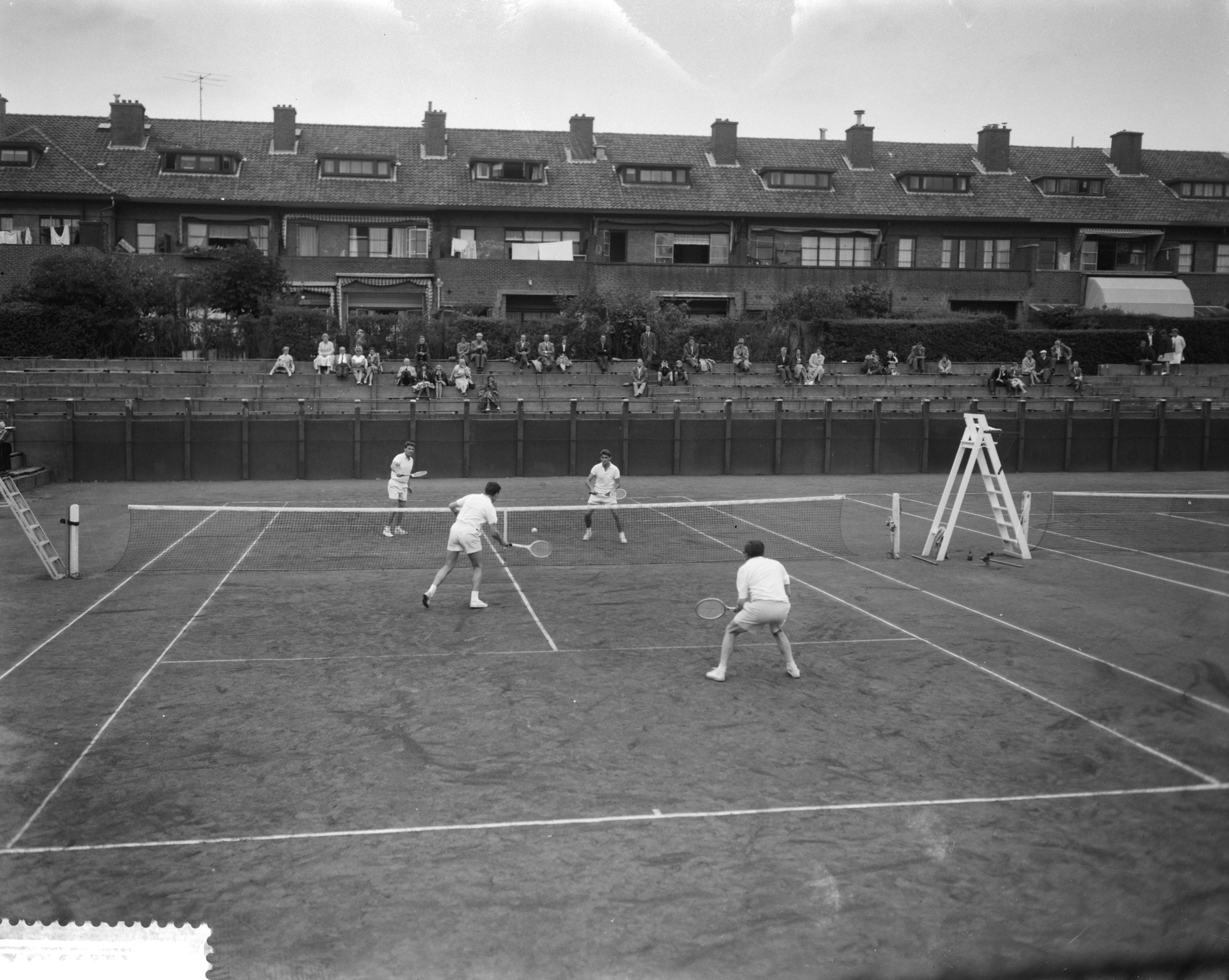 Fotocollectie Anefo — Nationale tenniskampioenschappen op de METS-banen te Scheveningen. Een kwartfinalepartij Herendubbel — Foto: Bilsen, Joop van / Anefo. Licentie: Set B: Rechtenvrij / Publiek Domein. Bron: Nationaal Archief. http://hdl.handle.net/10648/a9b6d882-d0b4-102d-bcf8-003048976d84