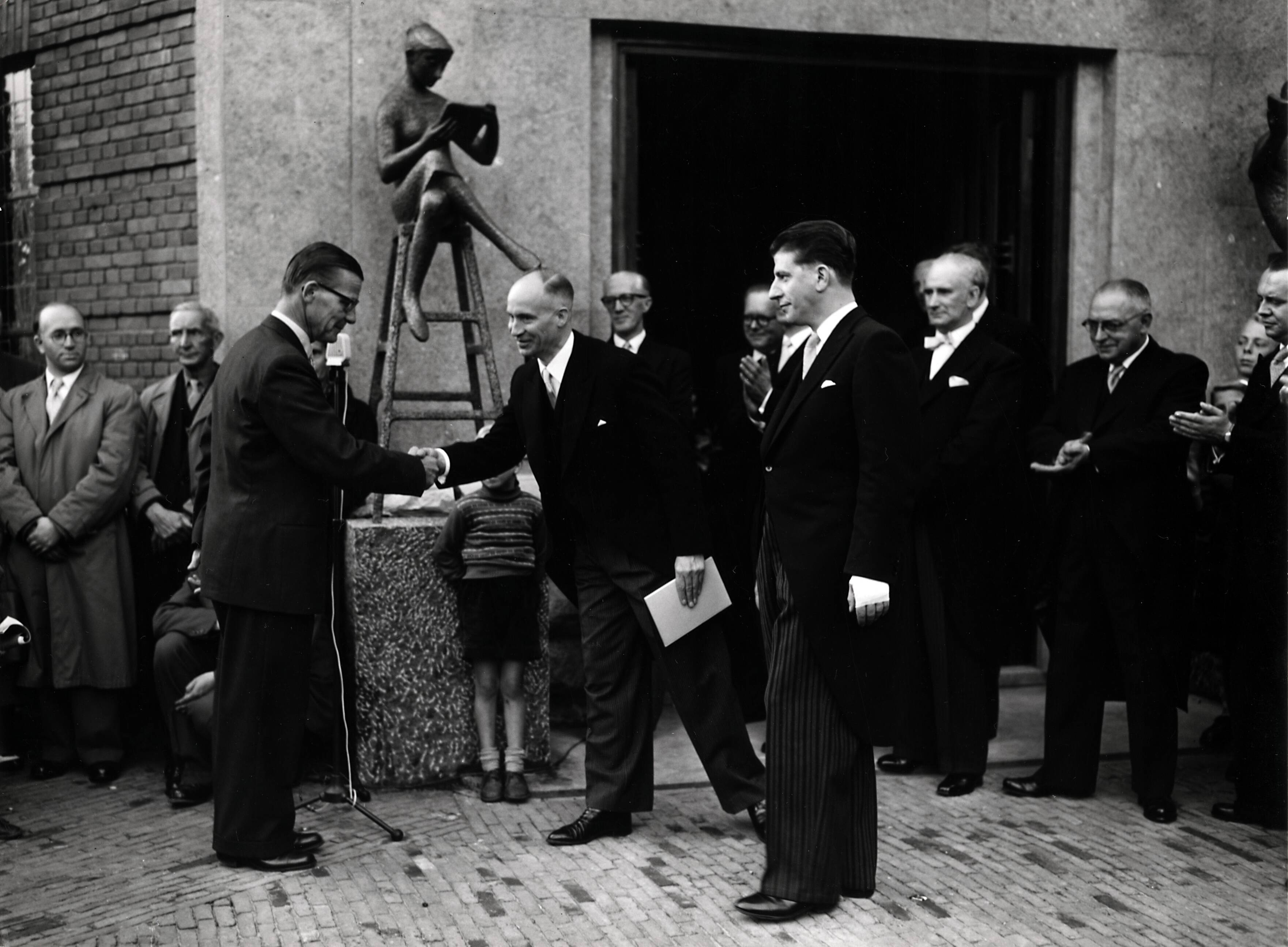 Collectie nader te bepalen — [50-jarig jubileum N.V. De Spaarnestad] [onthulling van de beelden van Hans Petri bij de hoofdingang van het Spaarnestadgebouw aan de Nassaulaan te Haarlem] — Foto: Fotograaf Onbekend / Fotobureau onbekend / Spaarnestad Photo (05887). Licentie: Set B: Rechtenvrij / Publiek Domein. Bron: Nationaal Archief. http://hdl.handle.net/10648/35429da6-3a70-a382-e063-6df0900a6686
