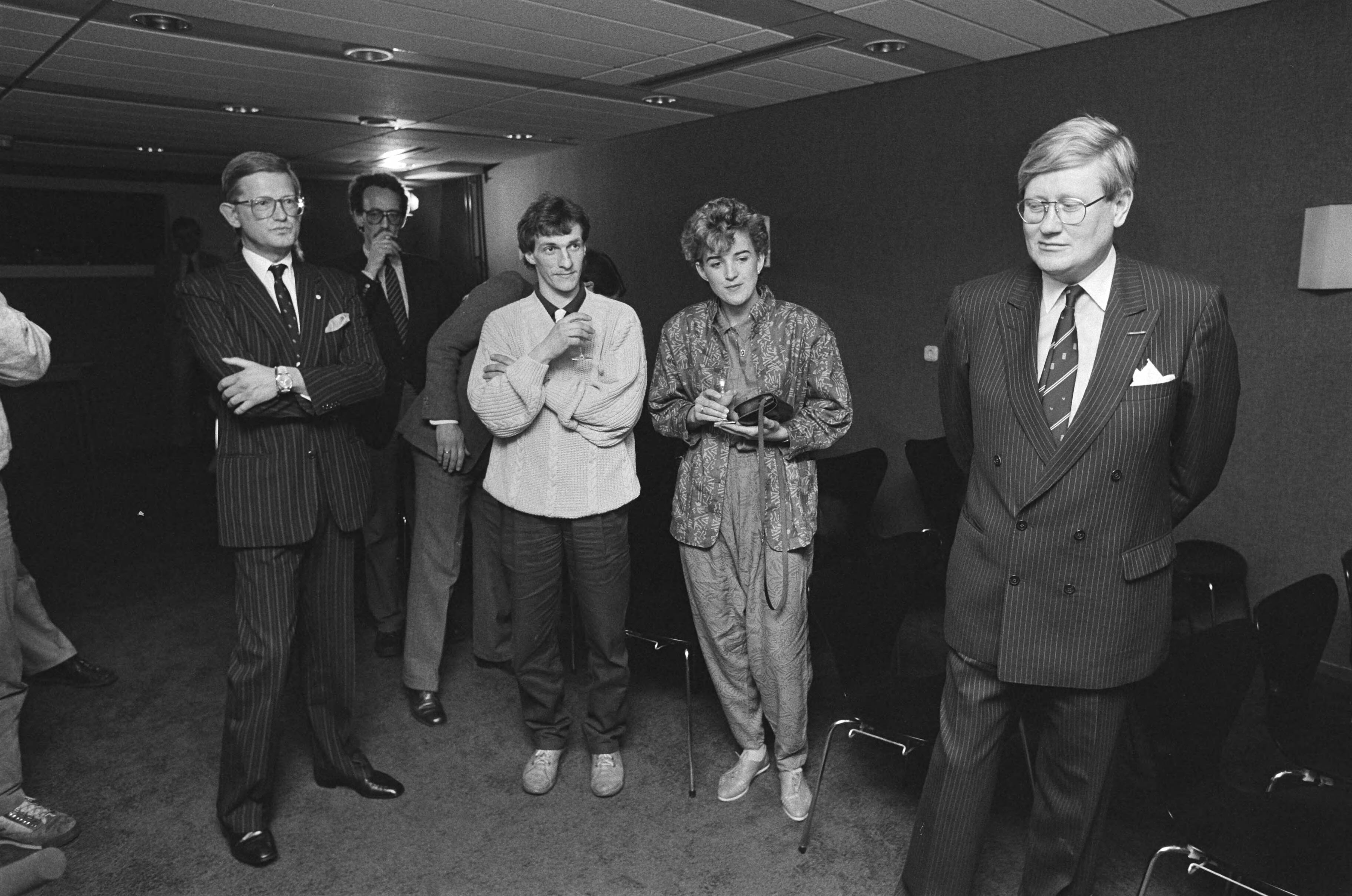 Mr. Pieter van Vollenhoven ontvangt de eerste videocassette van de Elfstedentocht — V.l.n.r. Voorzitter mr. Pieter van Vollenhoven, Evert van Benthem, Jeanette van Benthem, Hans Wiegel — Foto: Bogaerts, Rob / Anefo. Licentie: Set B: Rechtenvrij / Publiek Domein. Bron: Nationaal Archief. http://hdl.handle.net/10648/ad5086c8-d0b4-102d-bcf8-003048976d84
