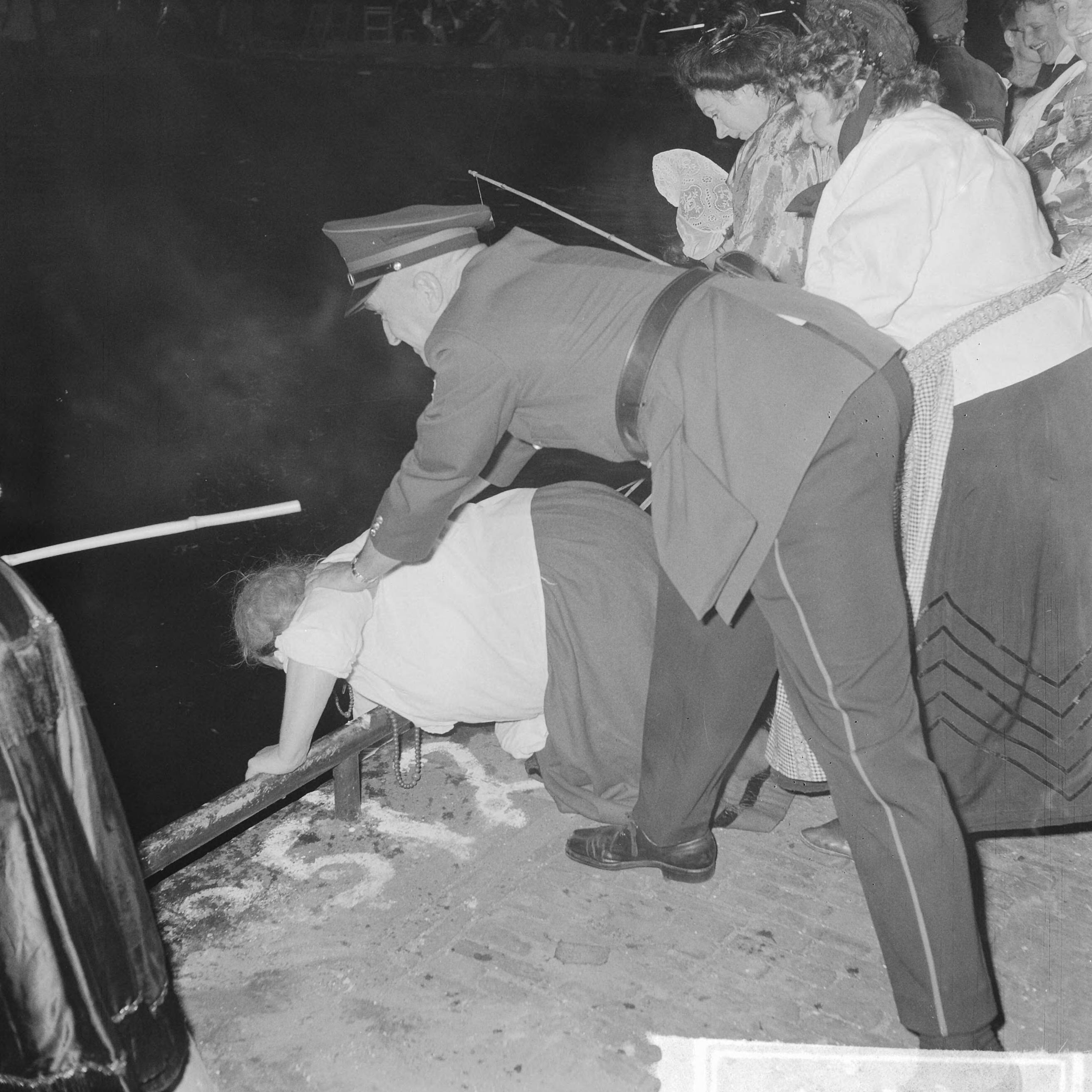 Fotocollectie Anefo — Viswedstrijd van het Jordaanse "Vrouwenviscollege" in de Brouwersgracht. Politieagent voorkomt dat Jordaanse dame in het water valt — Foto: Nijs, Jac. de / Anefo. Licentie: Set B: Rechtenvrij / Publiek Domein. Bron: Nationaal Archief. http://hdl.handle.net/10648/aa170b76-d0b4-102d-bcf8-003048976d84