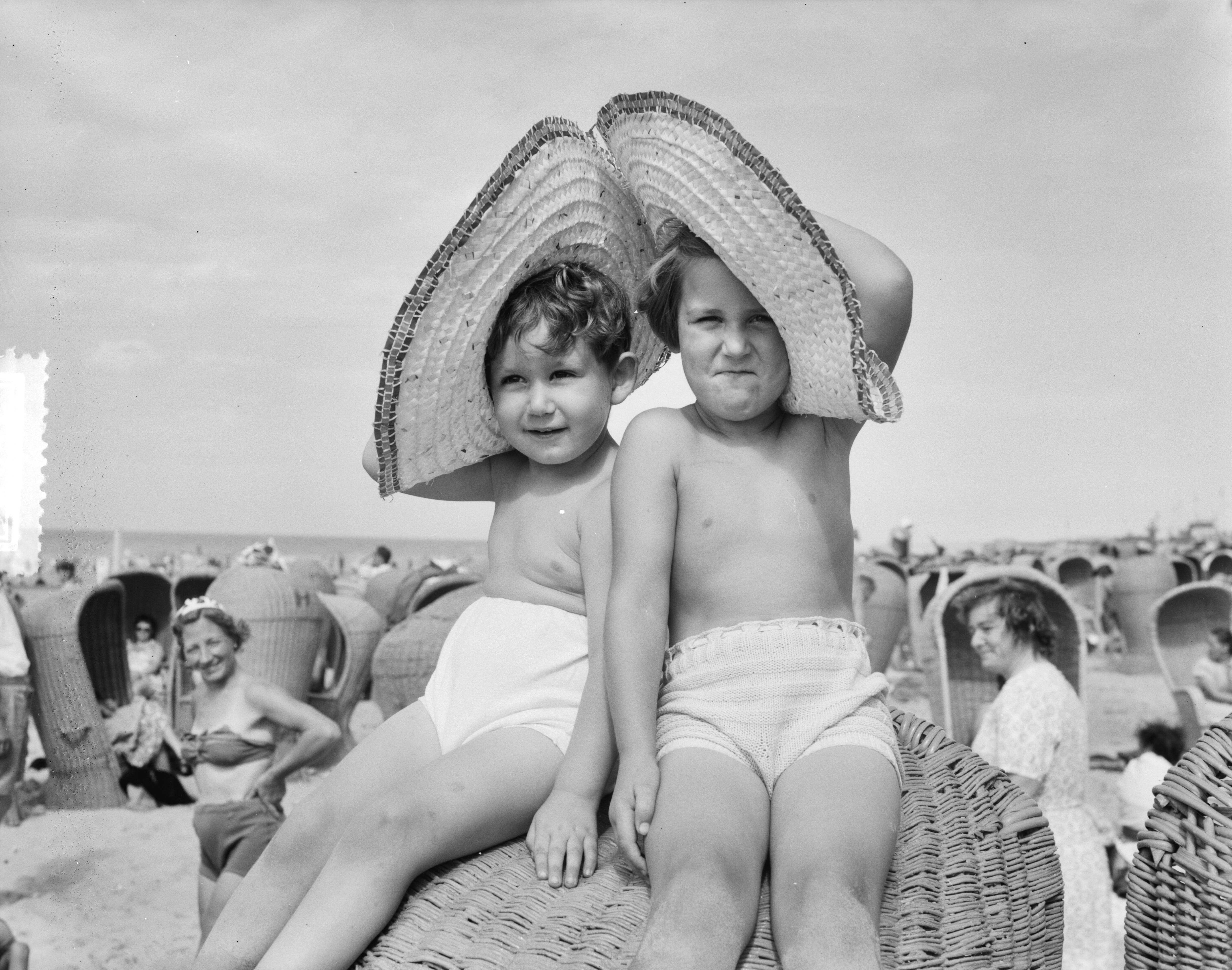 Fotocollectie Anefo — Strandplaatjes Scheveningen. Kinderen met zonnehoeden — Foto: Consenheim, Wim / Anefo. Licentie: Set B: Rechtenvrij / Publiek Domein. Bron: Nationaal Archief. http://hdl.handle.net/10648/a8fe4ff6-d0b4-102d-bcf8-003048976d84