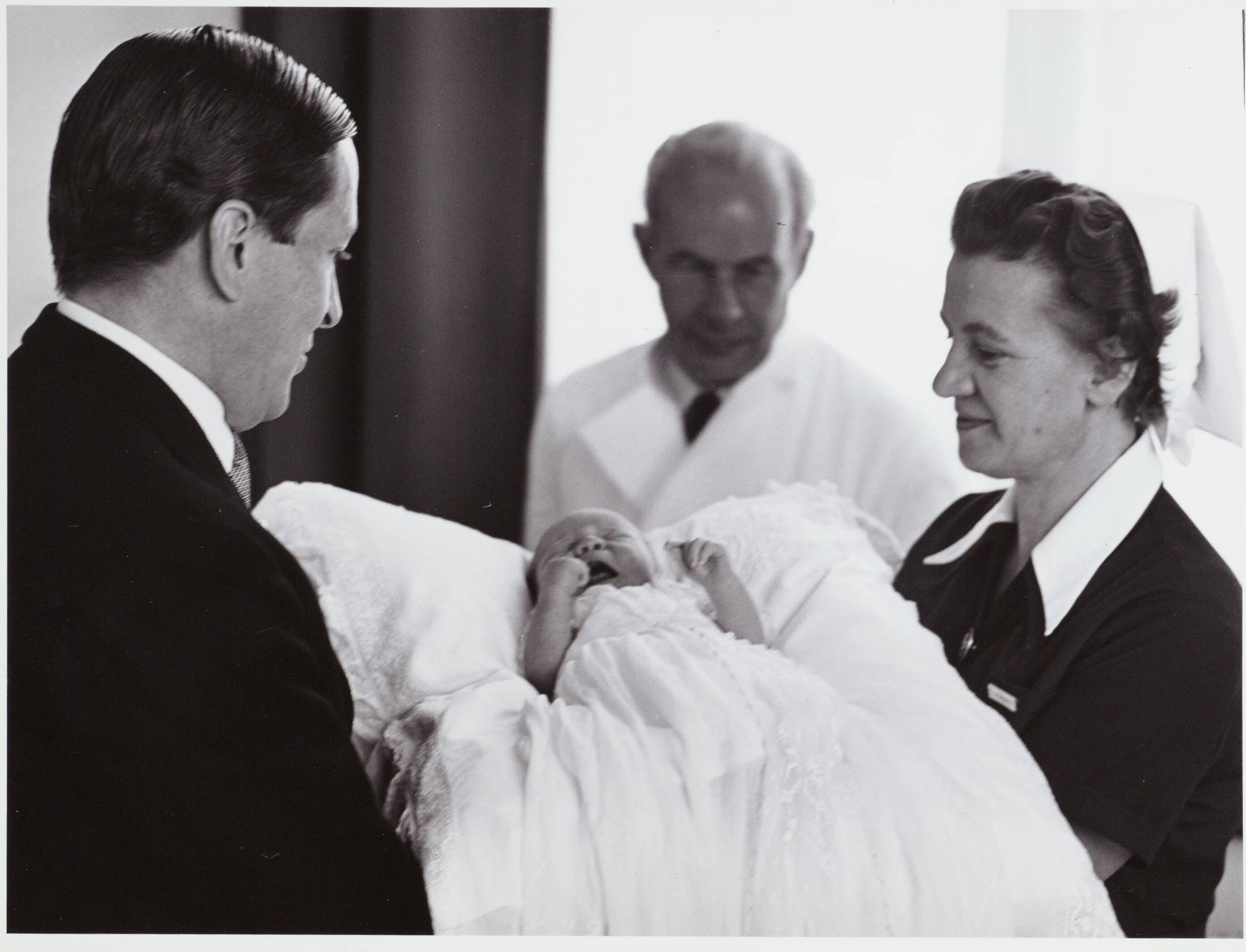 Fotocollectie RVD / Koninklijk Huis — Prins Claus geeft de baby prins Willem-Alexander weer over aan de verpleegster in het Academisch Ziekenhuis Utrecht op 2 mei 1967 — Foto: Nationaal Foto Persbureau / RVD. Licentie: Set B: Rechtenvrij / Publiek Domein. Bron: Nationaal Archief. http://hdl.handle.net/10648/afaf2a6e-d0b4-102d-bcf8-003048976d84