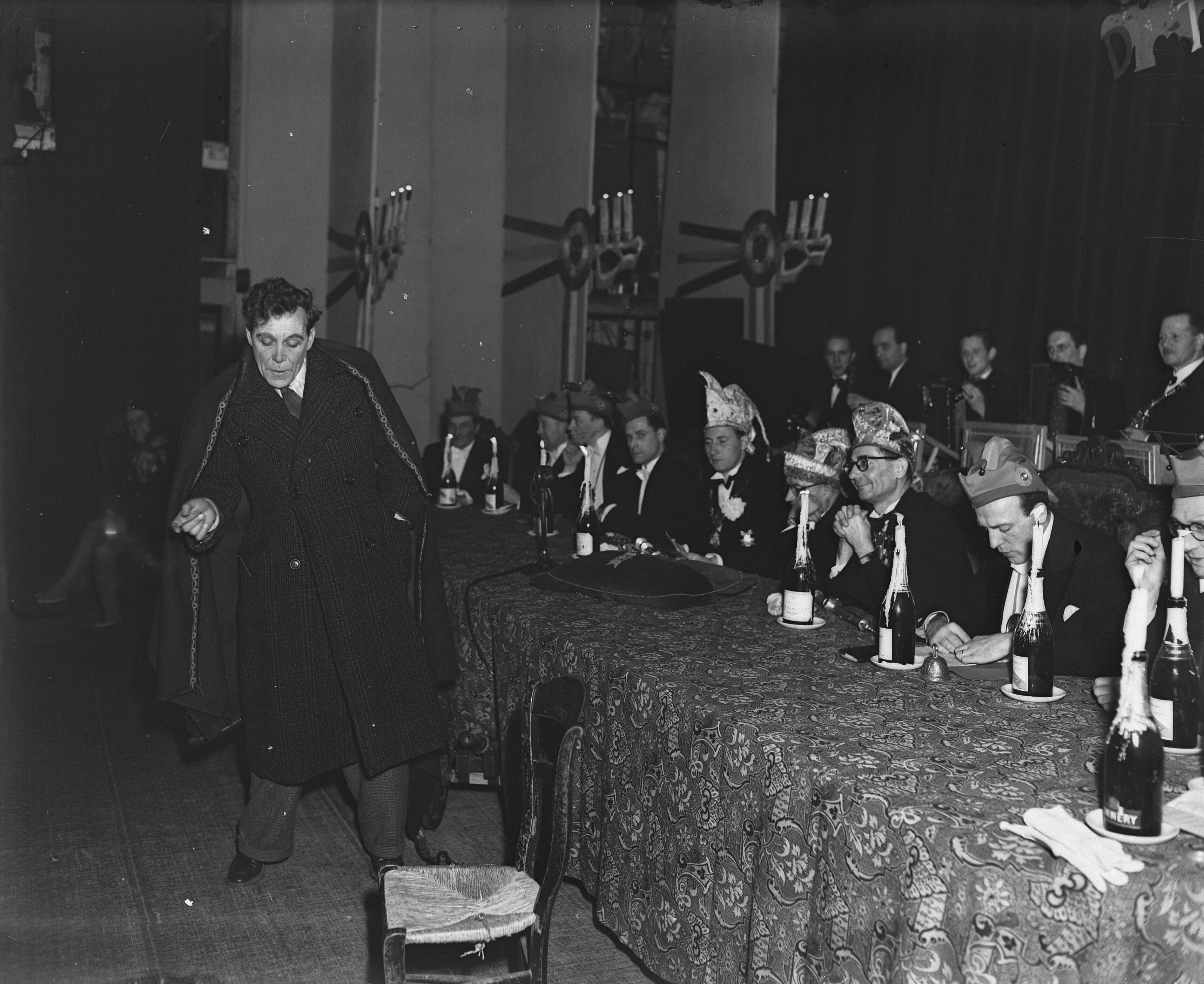Fotocollectie Anefo — Uitroeping van Prins Carnaval 1948 te Maastricht. Nar voor tafel van Raad van Elf — Foto: Snikkers, Anton / Anefo. Licentie: Set B: Rechtenvrij / Publiek Domein. Bron: Nationaal Archief. http://hdl.handle.net/10648/a8b1b3e4-d0b4-102d-bcf8-003048976d84