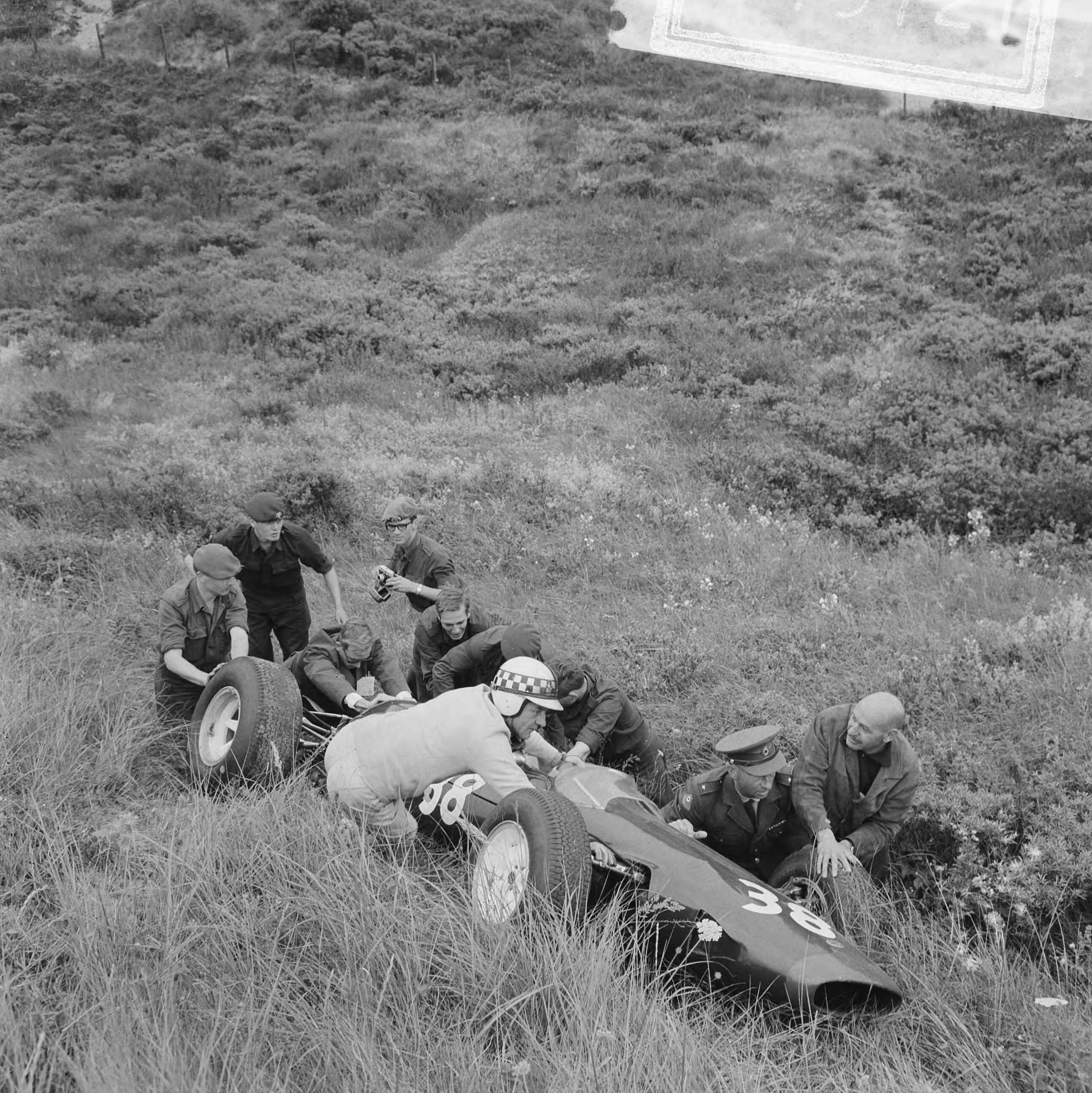 Fotocollectie Anefo — Training Zandvoort Grand Prix, enige soldaten helpen coureur Innes Ireland met zijn uit de baan geraakte auto — Foto: Nijs, Jac. de / Anefo. Licentie: Set B: Rechtenvrij / Publiek Domein. Bron: Nationaal Archief. http://hdl.handle.net/10648/aab4a3ae-d0b4-102d-bcf8-003048976d84
