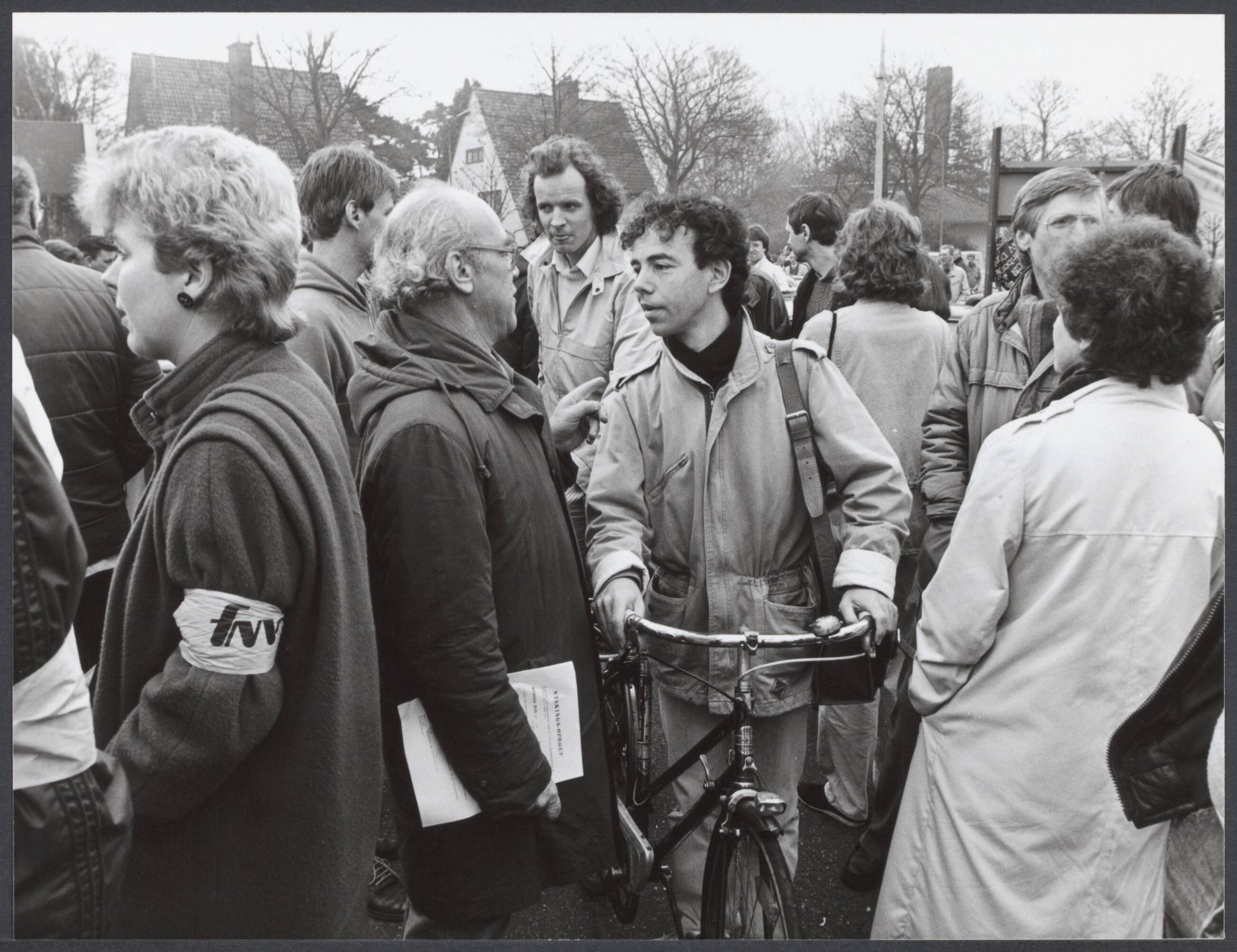 Radioraad, radio- en televisiepolitiek — Vanmorgen is bij de omroepen een staking begonnen die tot vanavond 12.00 zal duren. Dit uit protest tegen het besluit van minister Brinkman om de omroep-cao alsnog af te wijzen. Postende stakers discussiëren bij de poort van het omroepkwartier met enkele werkwilligen — Foto: Croes, Rob C. / Anefo. Licentie: Set B: Rechtenvrij / Publiek Domein. Bron: Nationaal Archief. http://hdl.handle.net/10648/231d572c-c4db-b9cb-bb82-187bcffc958c