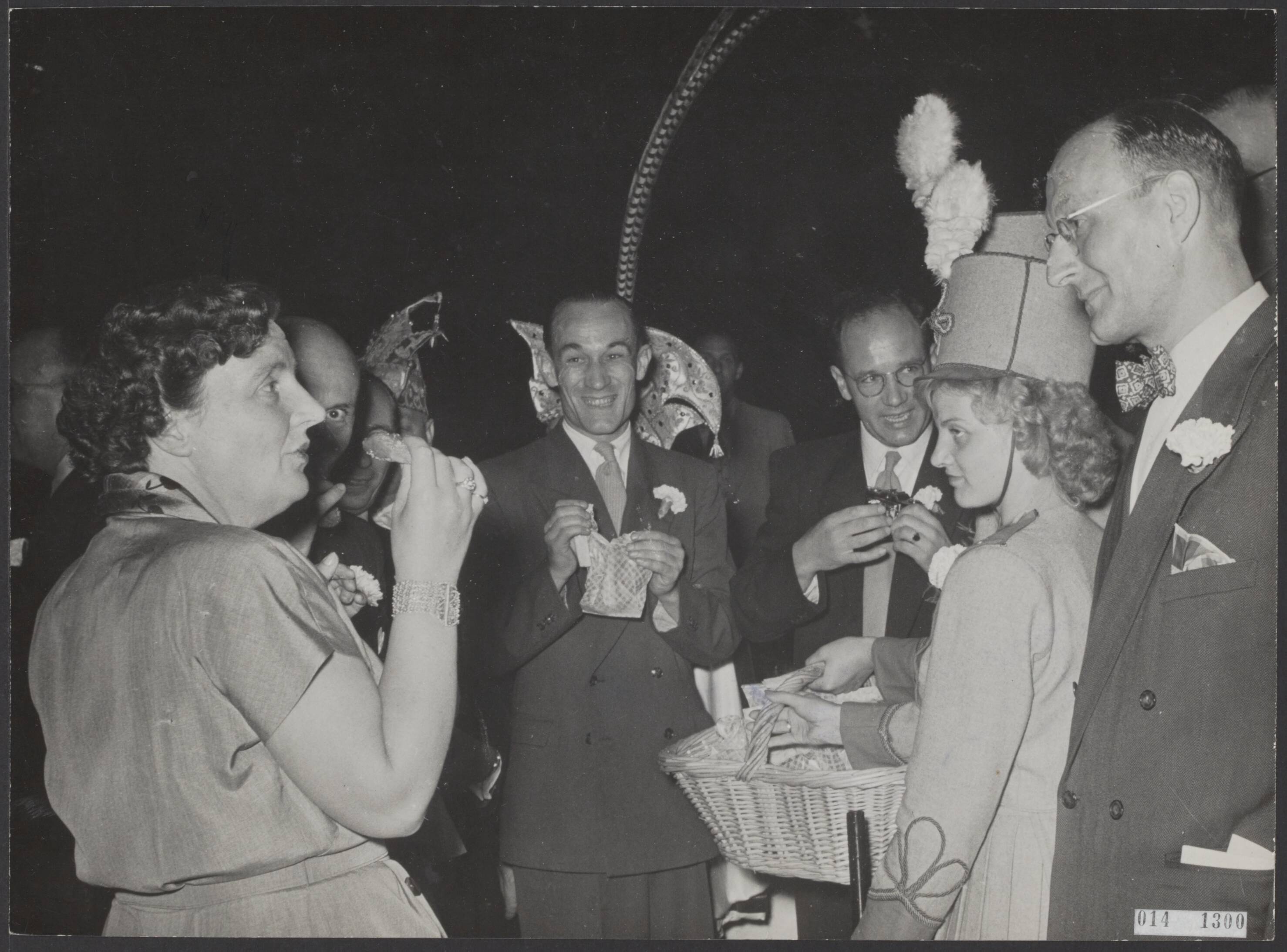 Fotocollectie Elsevier Binnenland — Op het paleis Soestdijk heeft koningin Juliana enige cabaretgezelschappen ontvangen welke zich voor de anjeractie hebben onderscheiden in Limburg. Er heerste in de tuin van het paleis een volkomen carnavalsstemming. [uitdelen Nonnevotten. Speciaal gebak uit Sittard] — Foto: Noske, J.D. / Anefo. Licentie: Set B: Rechtenvrij / Publiek Domein. Bron: Nationaal Archief. http://hdl.handle.net/10648/adb35a8c-d0b4-102d-bcf8-003048976d84