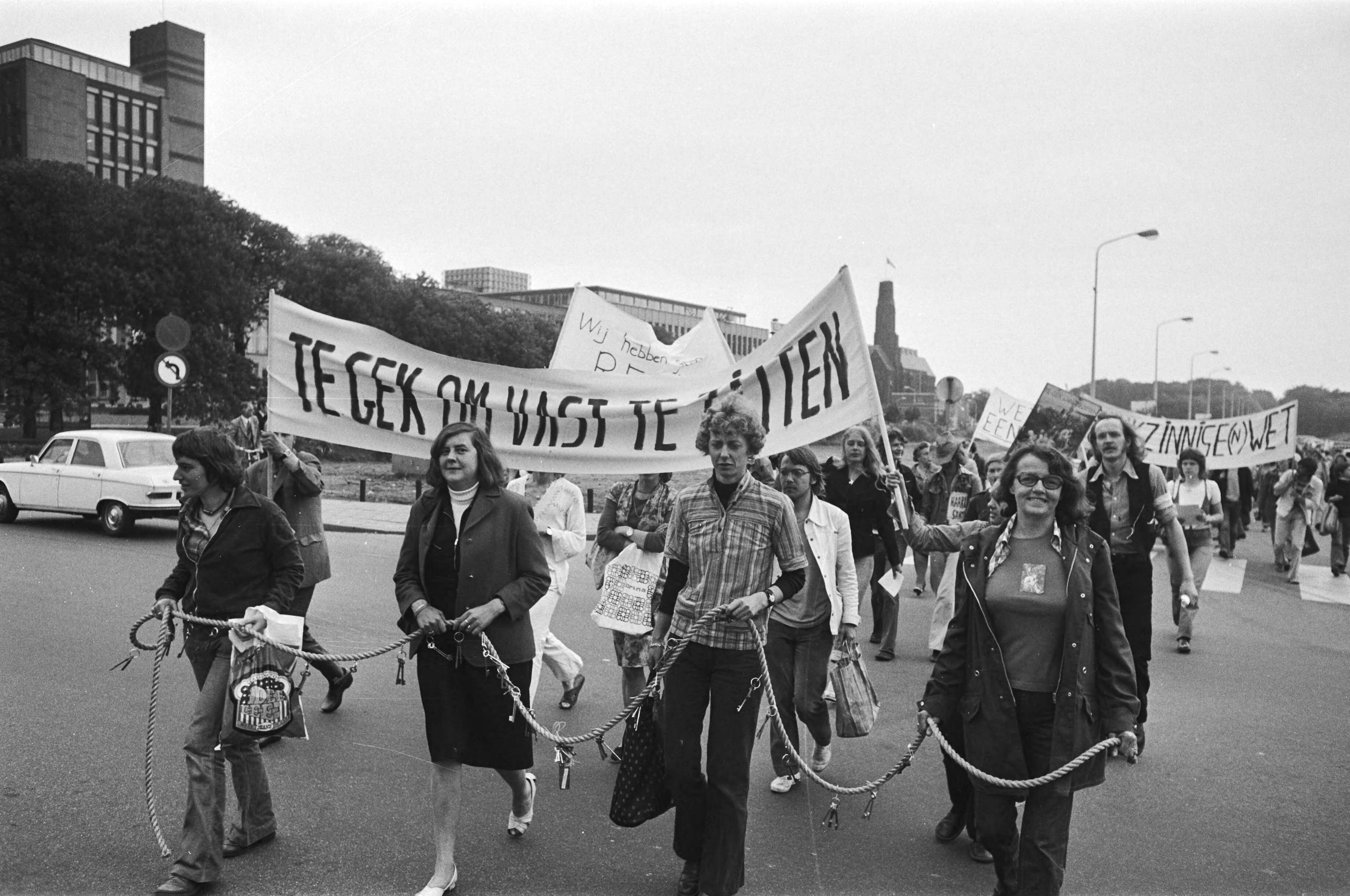 Fotocollectie Anefo — Demonstratie tegen krankzinnigheidswet " te gek om vast te zitten " in Den Haag , aan touwen gebonden demonstranten — Foto: Verhoeff, Bert / Anefo. Licentie: Set B: Rechtenvrij / Publiek Domein. Bron: Nationaal Archief. http://hdl.handle.net/10648/ac849a18-d0b4-102d-bcf8-003048976d84