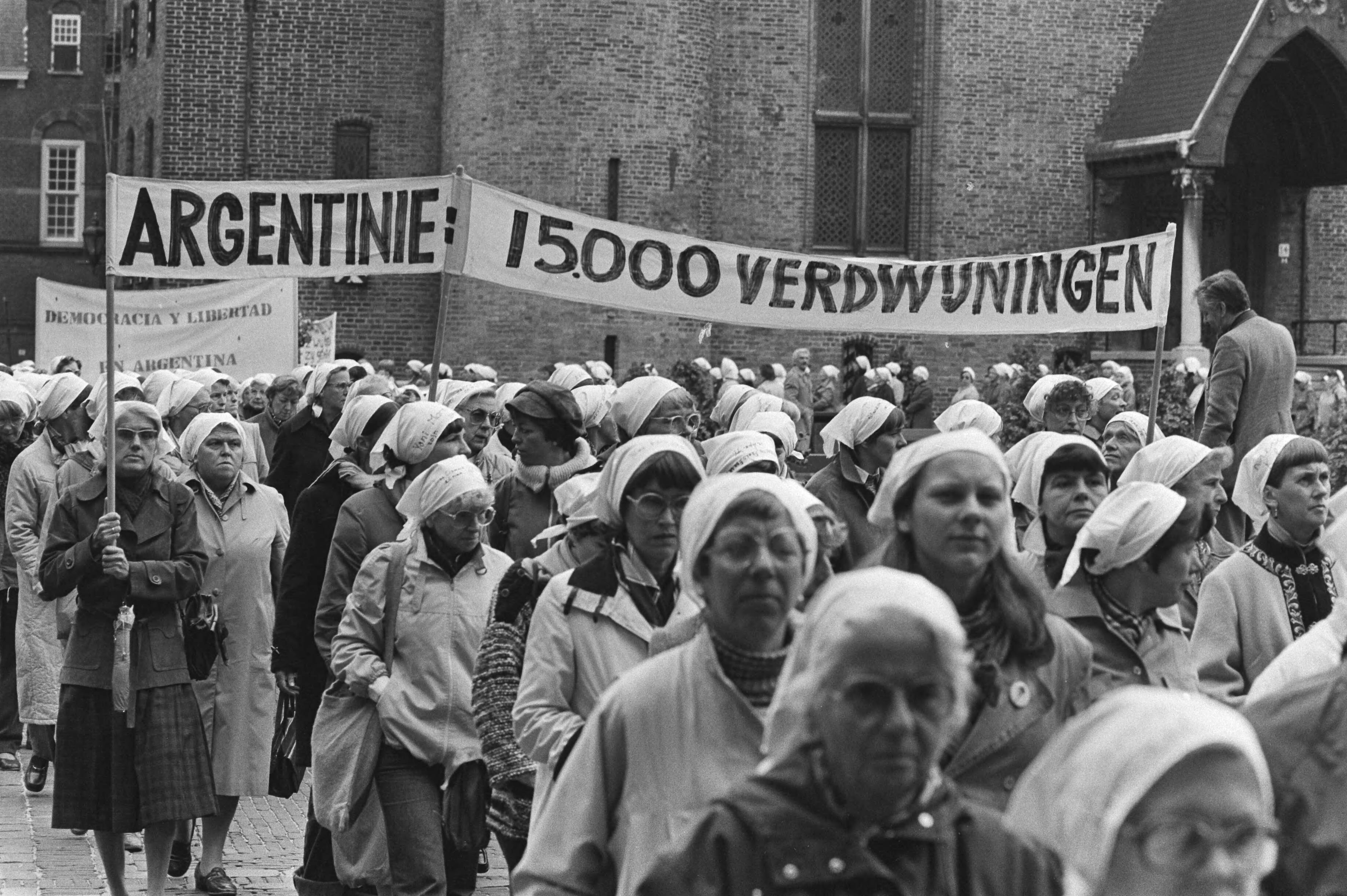 Demonstratie door vrouwen uit solidariteit met de "Dwaze Moeders" van Playa del Mayo in Den Haag — Optocht met spandoek — Foto: Bogaerts, Rob / Anefo. Licentie: Set B: Rechtenvrij / Publiek Domein. Bron: Nationaal Archief. http://hdl.handle.net/10648/ad065cba-d0b4-102d-bcf8-003048976d84