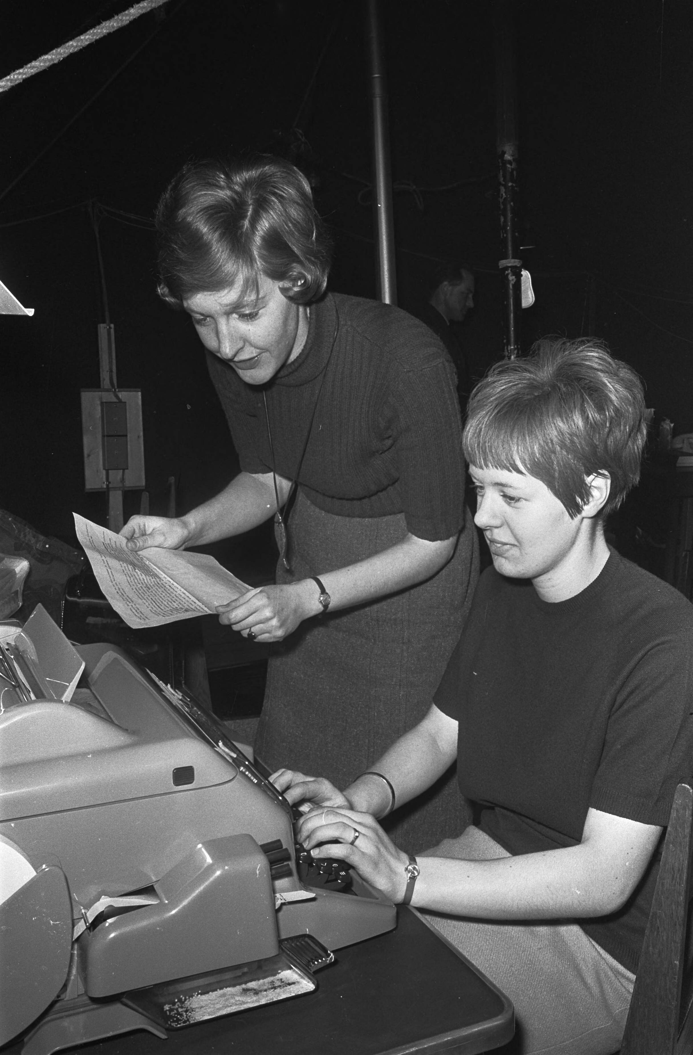 Fotocollectie Anefo — In het perscentrum in Lage Vuursche komt elke dag ANP-verslaggeefster Elly boer haar berichten doorgeven aan de dames van de PTT die de telex bedienen en op die manier zorgen dat het nieuws van Drakenstein wereldkundig wordt gemaakt. Als straks de baby geboren is zal zij hier ook staan om dan die mededeling door te geven, waarna de hele wereld het zal weten. — Foto: Koch, Eric / Anefo. Licentie: Set B: Rechtenvrij / Publiek Domein. Bron: Nationaal Archief. http://hdl.handle.net/10648/ab1531ec-d0b4-102d-bcf8-003048976d84