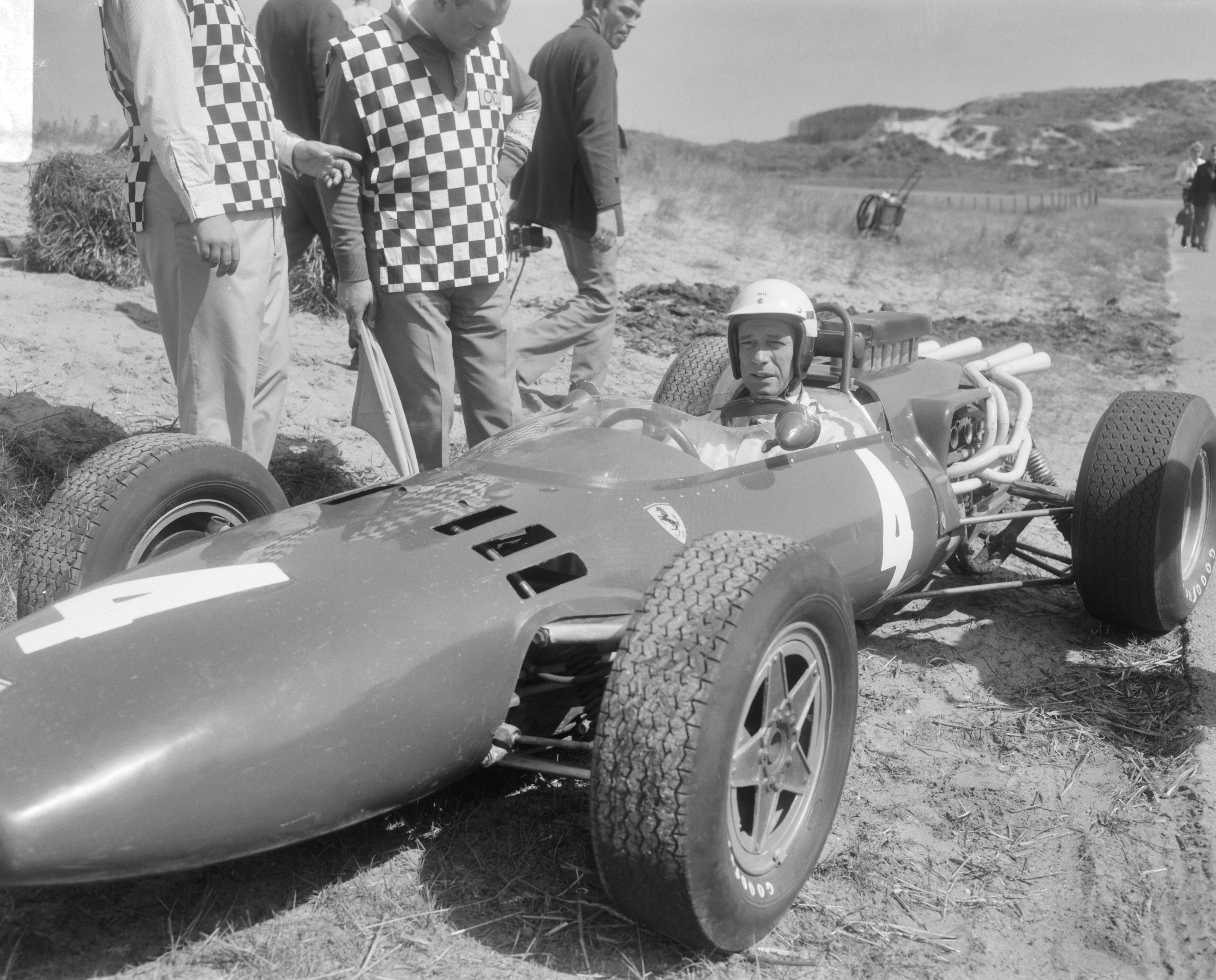 Fotocollectie Anefo — Cineramafilm "Grand Prix", filmopnames op het circuit van Zandvoort, rechts Yves Montand [als coureur Jean-Pierre Sarti] in zijn Ferrari — Foto: Bilsen, Joop van / Anefo. Licentie: Set B: Rechtenvrij / Publiek Domein. Bron: Nationaal Archief. http://hdl.handle.net/10648/aaf3c098-d0b4-102d-bcf8-003048976d84