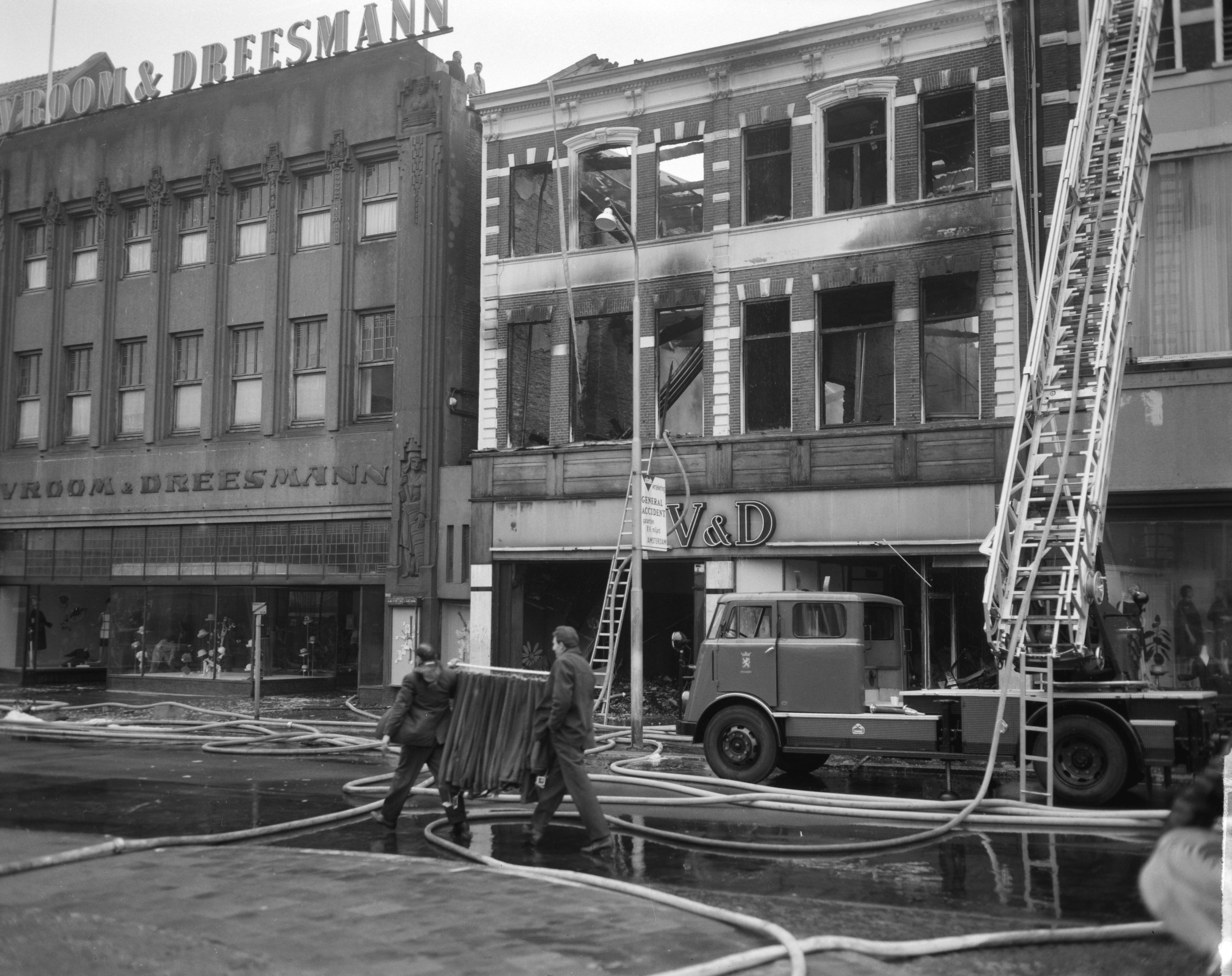 Fotocollectie Anefo — Brand bij V&D te Leeuwarden. Onbeschadigde confectie wordt in veiligheid gebracht — Foto: Bilsen, Joop van / Anefo. Licentie: Set B: Rechtenvrij / Publiek Domein. Bron: Nationaal Archief. http://hdl.handle.net/10648/aa2ed986-d0b4-102d-bcf8-003048976d84