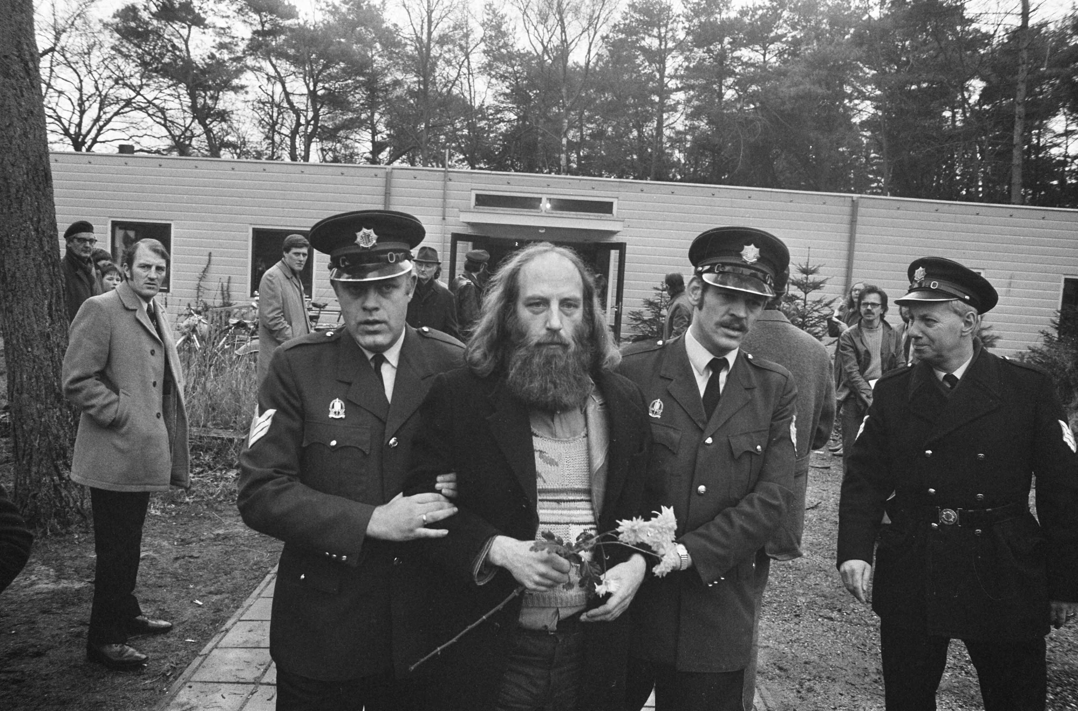 De directiekeet van zwakzinnigeninrichting Dennendal in Den Dolder wordt door de politie ontruimd — De ontslagen directeur drs. Carel Muller wordt door politie weggeleid — Foto: Fotograaf Onbekend / Anefo. Licentie: Set B: Rechtenvrij / Publiek Domein. Bron: Nationaal Archief. http://hdl.handle.net/10648/ac415afa-d0b4-102d-bcf8-003048976d84