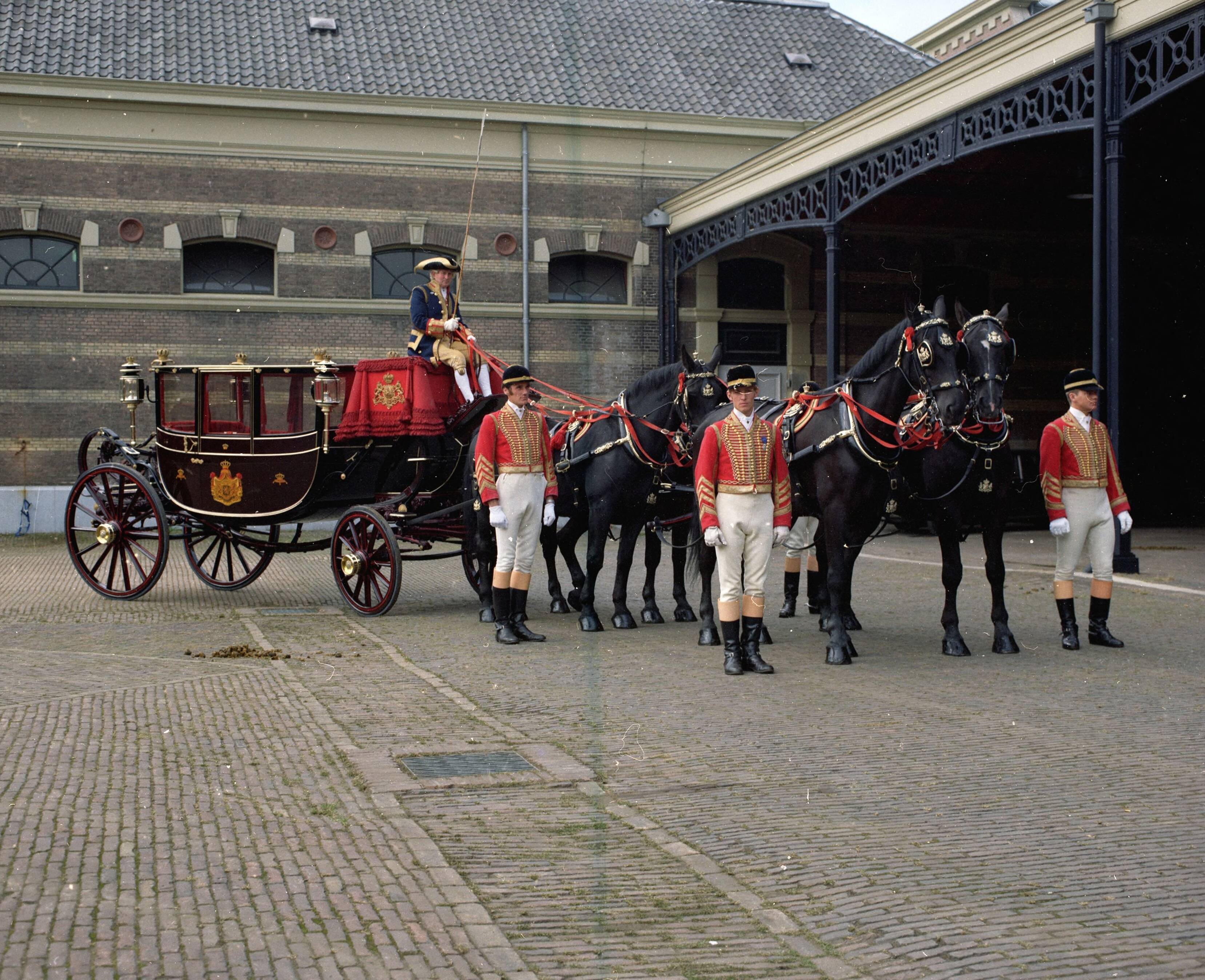 Fotocollectie RVD / Koninklijk Huis — De Glazen Koets met vier paarden, koetsier en stalpersoneel in uniform, op de binnenplaats van de koninklijke stallen aan de Noordwal in Den Haag — Foto: Mastenbroek, Cees / RVD. Licentie: Set B: Rechtenvrij / Publiek Domein. Bron: Nationaal Archief. http://hdl.handle.net/10648/afb27d18-d0b4-102d-bcf8-003048976d84