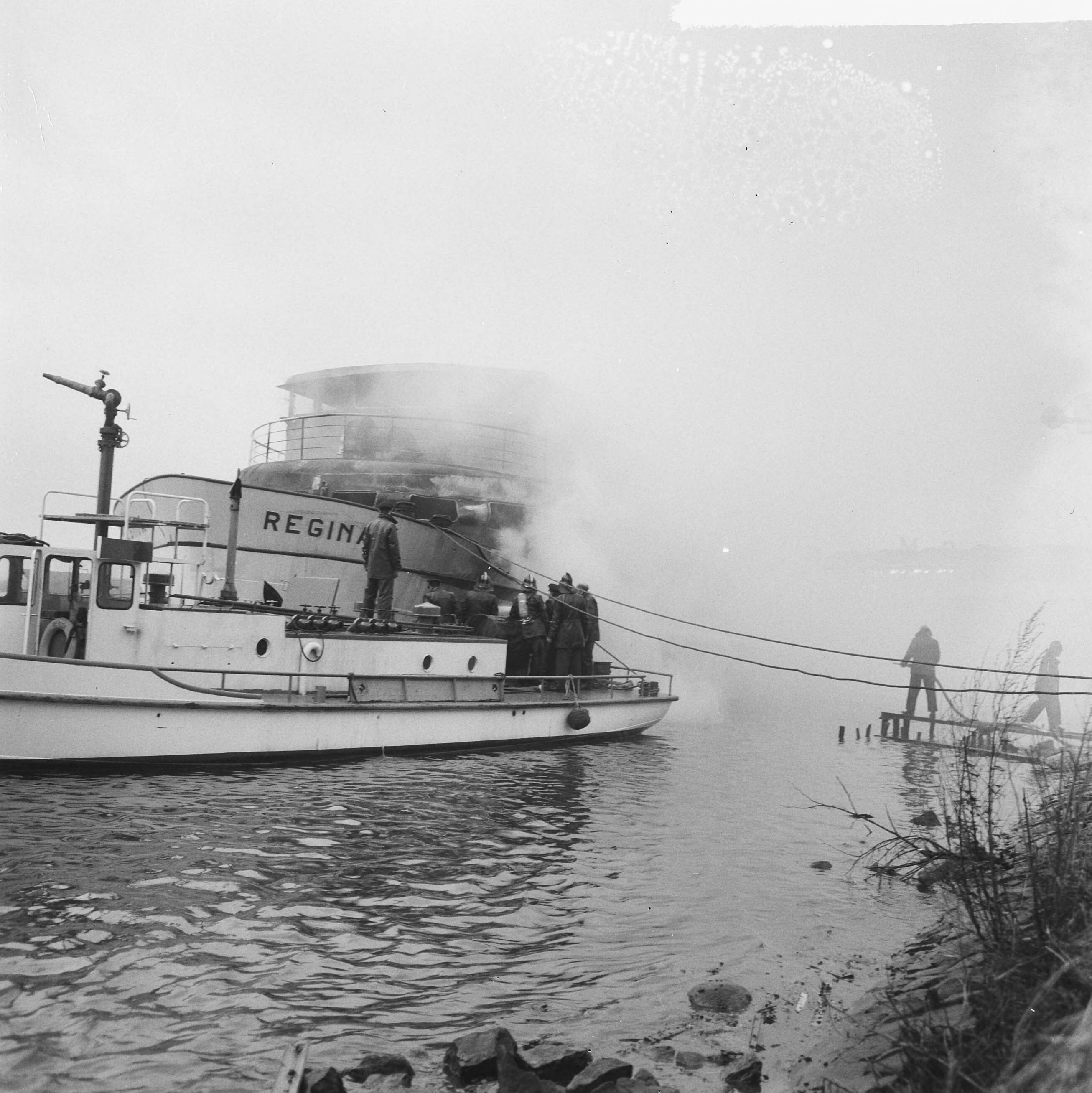 Fotocollectie Anefo — Brandweer tijdens het blussen van het passagierschip Regina bij de Zaanlandse te Zaandam, vanaf een scheepje — Foto: Evers, Joost / Anefo. Licentie: Set B: Rechtenvrij / Publiek Domein. Bron: Nationaal Archief. http://hdl.handle.net/10648/aad02322-d0b4-102d-bcf8-003048976d84