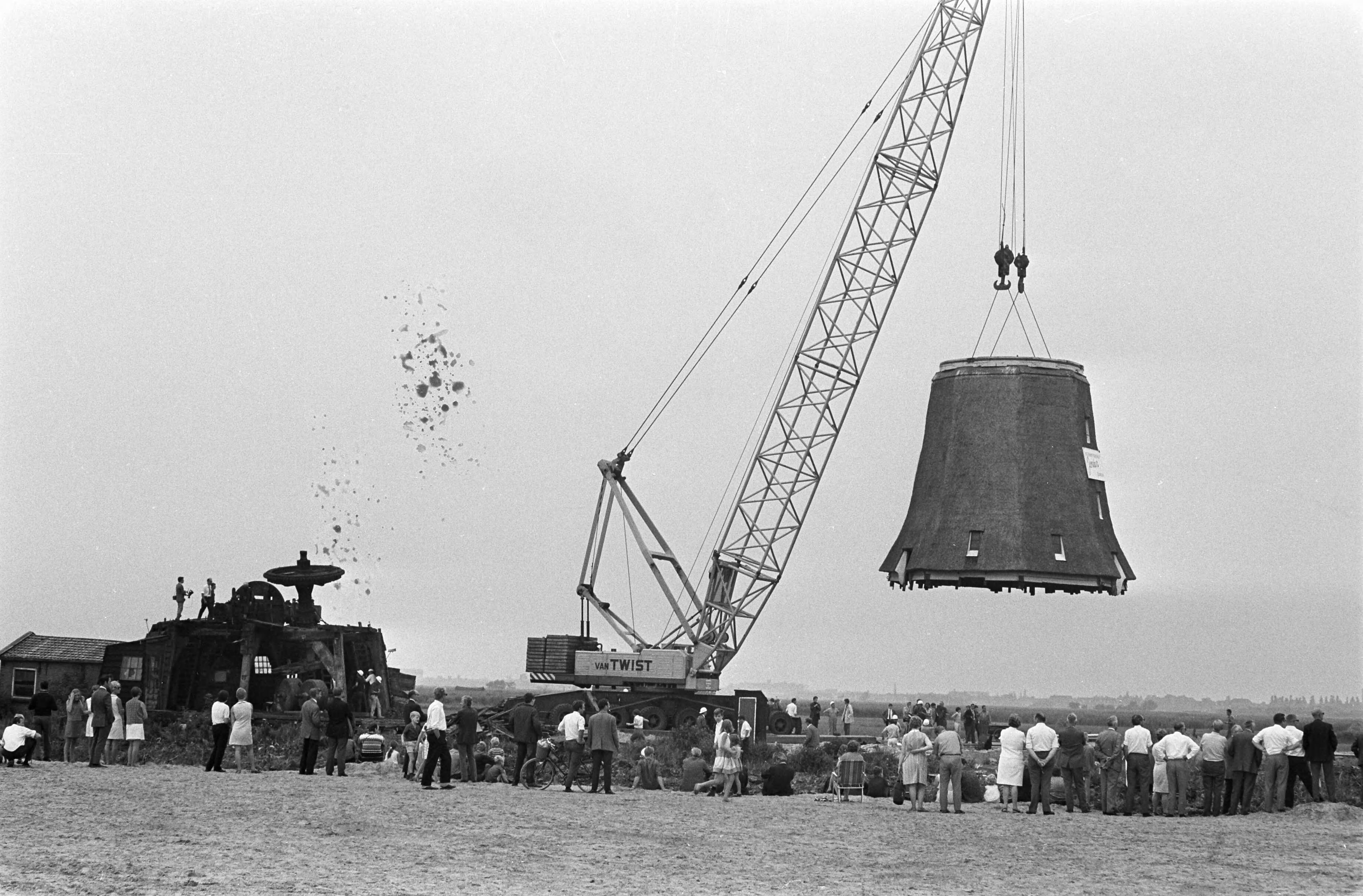 Verhuizing van de Zaanse oliemolen "de Zoeker" — Het middenstuk van de molen, hangend in de takels — Foto: Fotograaf Onbekend / Anefo. Licentie: Set B: Rechtenvrij / Publiek Domein. Bron: Nationaal Archief. http://hdl.handle.net/10648/ab48c8a4-d0b4-102d-bcf8-003048976d84