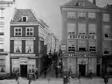 Fotocollectie Elsevier Binnenland — Venestraat te Den Haag, gezien vanaf de Groenmark. Aan beide zijden van de ingang van de Venestraat de bestelgoederenkantoren van Nederlandsche Rhijnspoorweg en Hollandsche IJzeren Spoorwegmaatschappij — Foto: Onbekend / Publiek Domein of Rechtenvrij. Licentie: Set B: Rechtenvrij / Publiek Domein. Bron: Nationaal Archief. http://hdl.handle.net/10648/addf78b0-d0b4-102d-bcf8-003048976d84