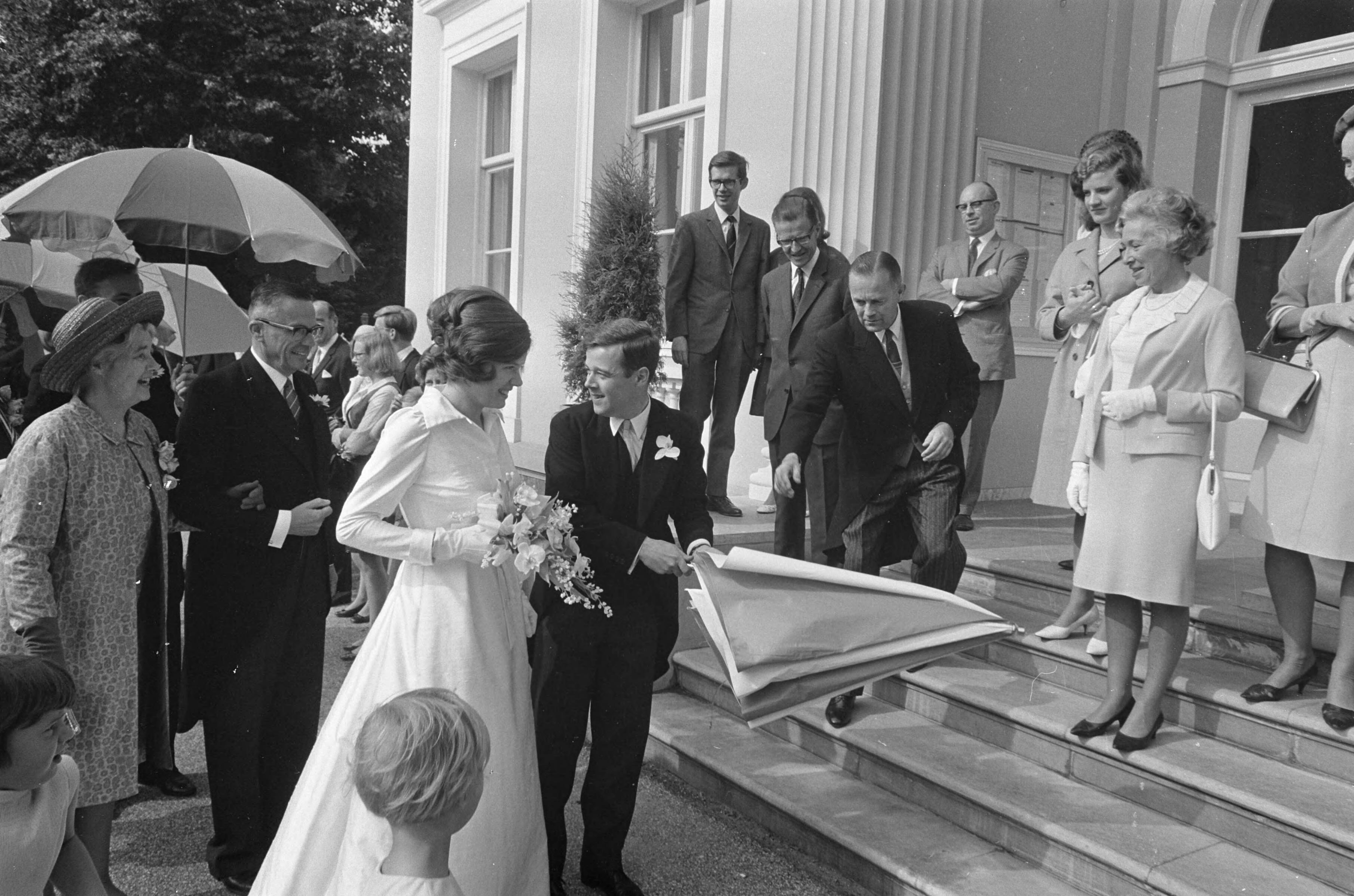 Fotocollectie Anefo — Oud burgemeester Amsterdam mr. G. van Hall huwelijk voltrokken van neef ir. A. F. van Hall te Bloemendaal. Oud-burgemeester feliciteert mevrouw van Hall Droste / — Foto: Kroon, Ron / Anefo. Licentie: Set B: Rechtenvrij / Publiek Domein. Bron: Nationaal Archief. http://hdl.handle.net/10648/ab46d364-d0b4-102d-bcf8-003048976d84