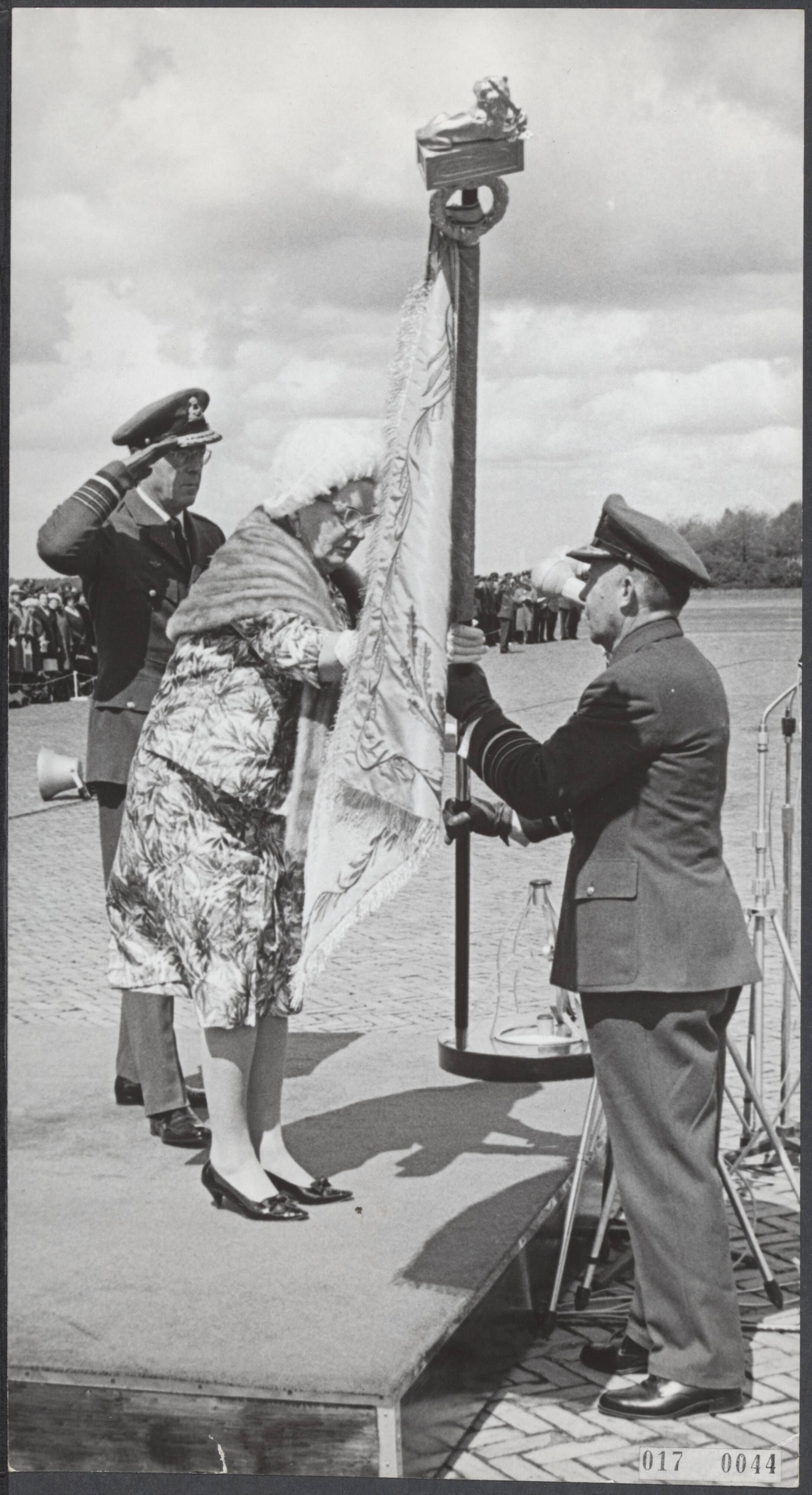 Fotocollectie Elsevier Binnenland — Koningin Juliana heeft op de vliegbasis Soesterberg de Koninklijke Luchtmacht haar vaandel gegeven. Uit handen van de koningin ontvangt luitenant-generaal A.B. Wolff, bevelhebber der Luchtstrijdkrachten het vaandel. Links prins Bernhard — Foto: Koch, Eric / Anefo. Licentie: Set B: Rechtenvrij / Publiek Domein. Bron: Nationaal Archief. http://hdl.handle.net/10648/adbc8c4c-d0b4-102d-bcf8-003048976d84