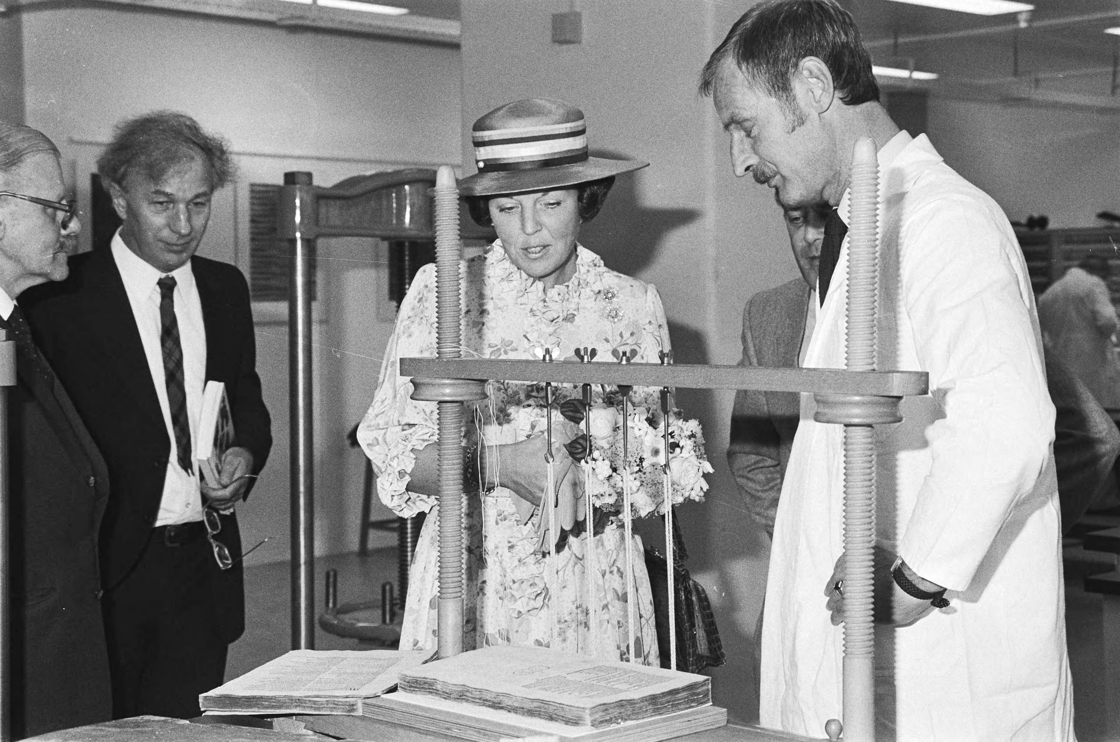 Koningin Beatrix opent de Koninklijke Bibliotheek in Den Haag — Koningin Beatrix op de boekenrestauratie-afdeling — Foto: Dijk, Hans van / Anefo. Licentie: Set B: Rechtenvrij / Publiek Domein. Bron: Nationaal Archief. http://hdl.handle.net/10648/ad1f3bfe-d0b4-102d-bcf8-003048976d84