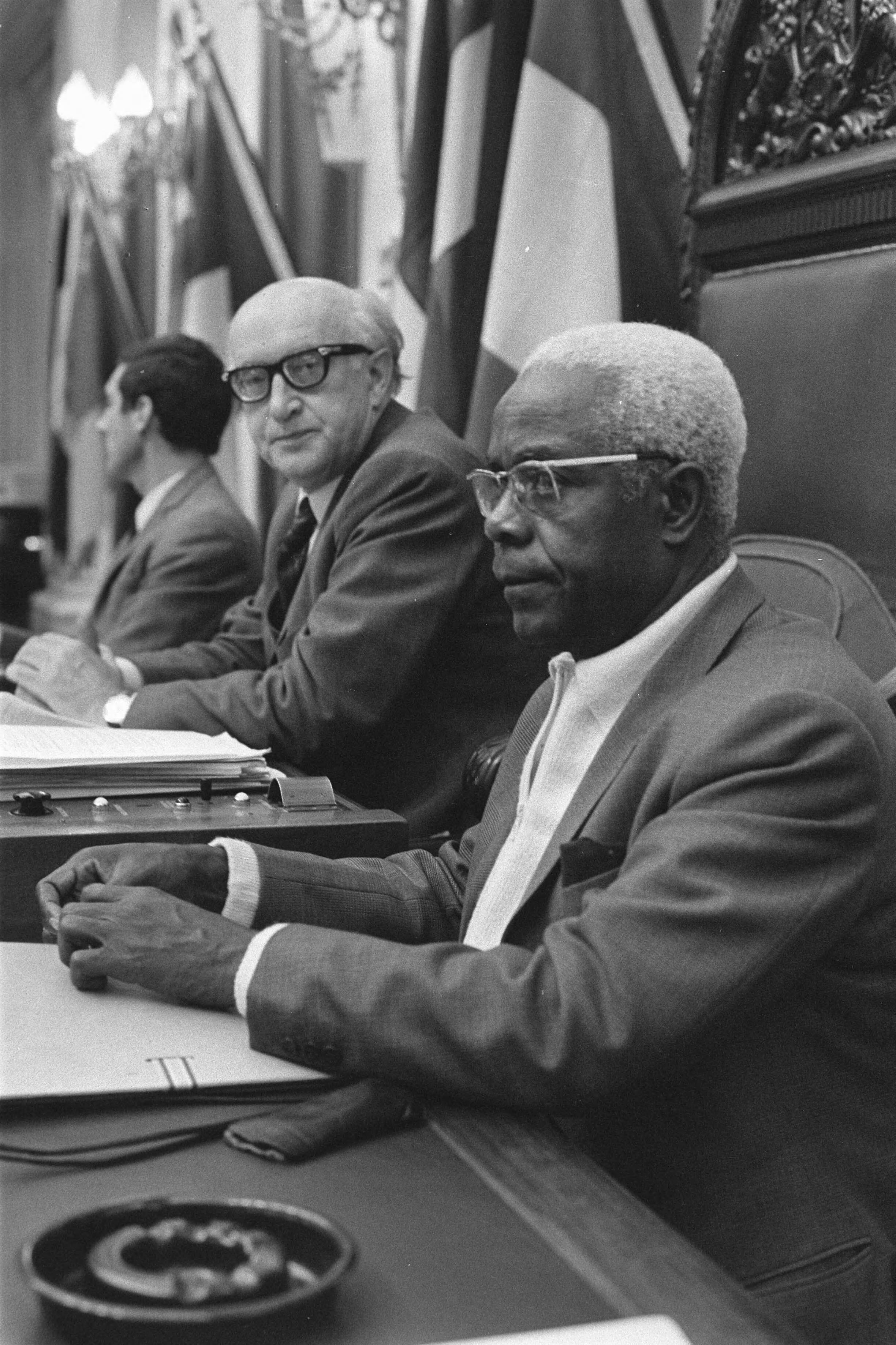 Fotocollectie Anefo — Voorvergadering congres over associaties EEG met Afrikaanse landen in Tweede Kamer Den Haag , (l) Aschenbach, (r) NgoO Mebe (Kameroen) — Foto: Verhoeff, Bert / Anefo. Licentie: Set B: Rechtenvrij / Publiek Domein. Bron: Nationaal Archief. http://hdl.handle.net/10648/abdd8214-d0b4-102d-bcf8-003048976d84