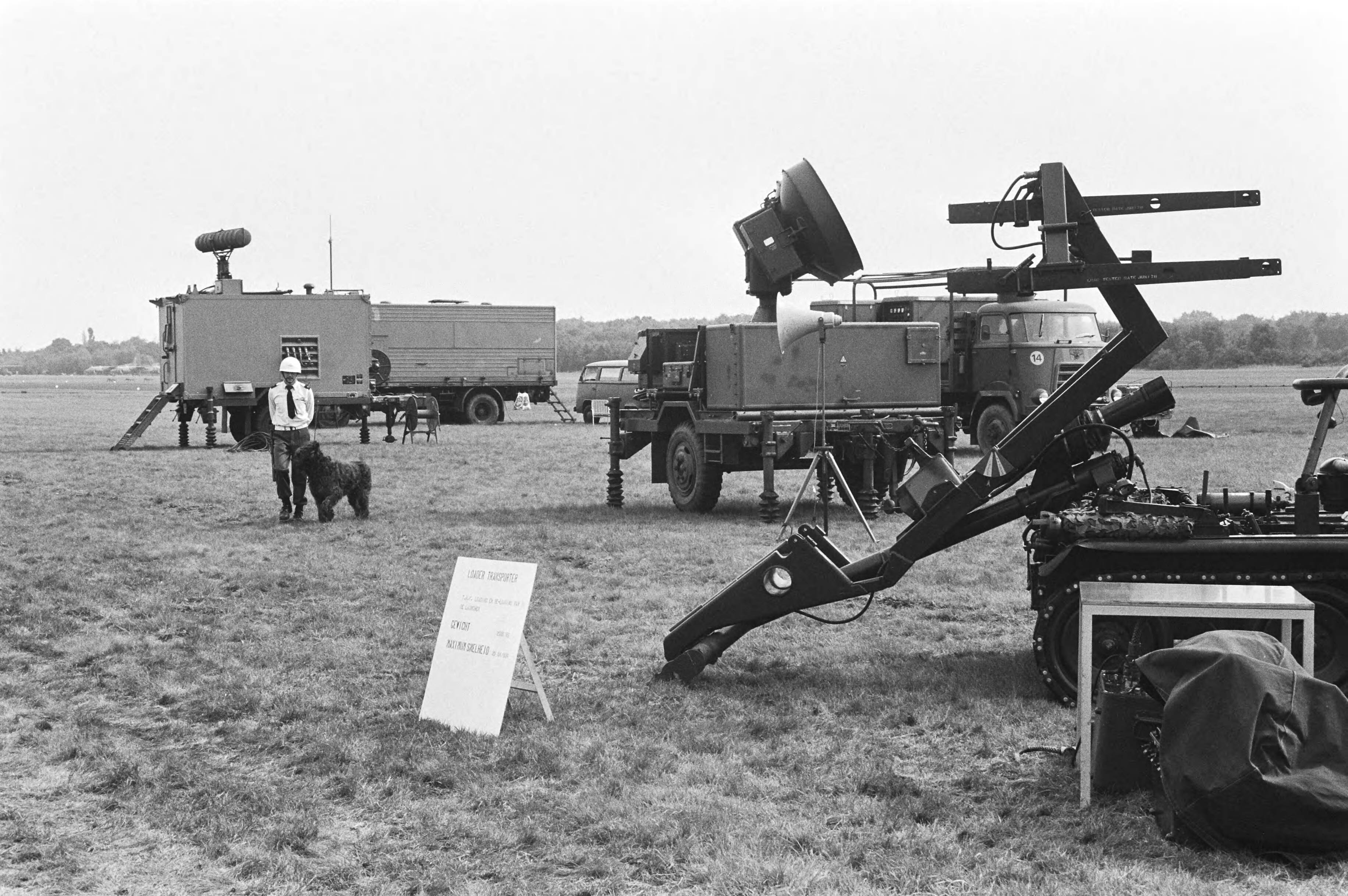 Open dag op luchtmachtbasis Soesterberg — De open dag op luchtmachtbasis Soesterberg tussen de raketluchtafweerinstallaties loopt een hondengeleider van het Luchtmacht Bewakings Corps — Foto: Dijk, Hans van / Anefo. Licentie: Set B: Rechtenvrij / Publiek Domein. Bron: Nationaal Archief. http://hdl.handle.net/10648/ad039d9a-d0b4-102d-bcf8-003048976d84